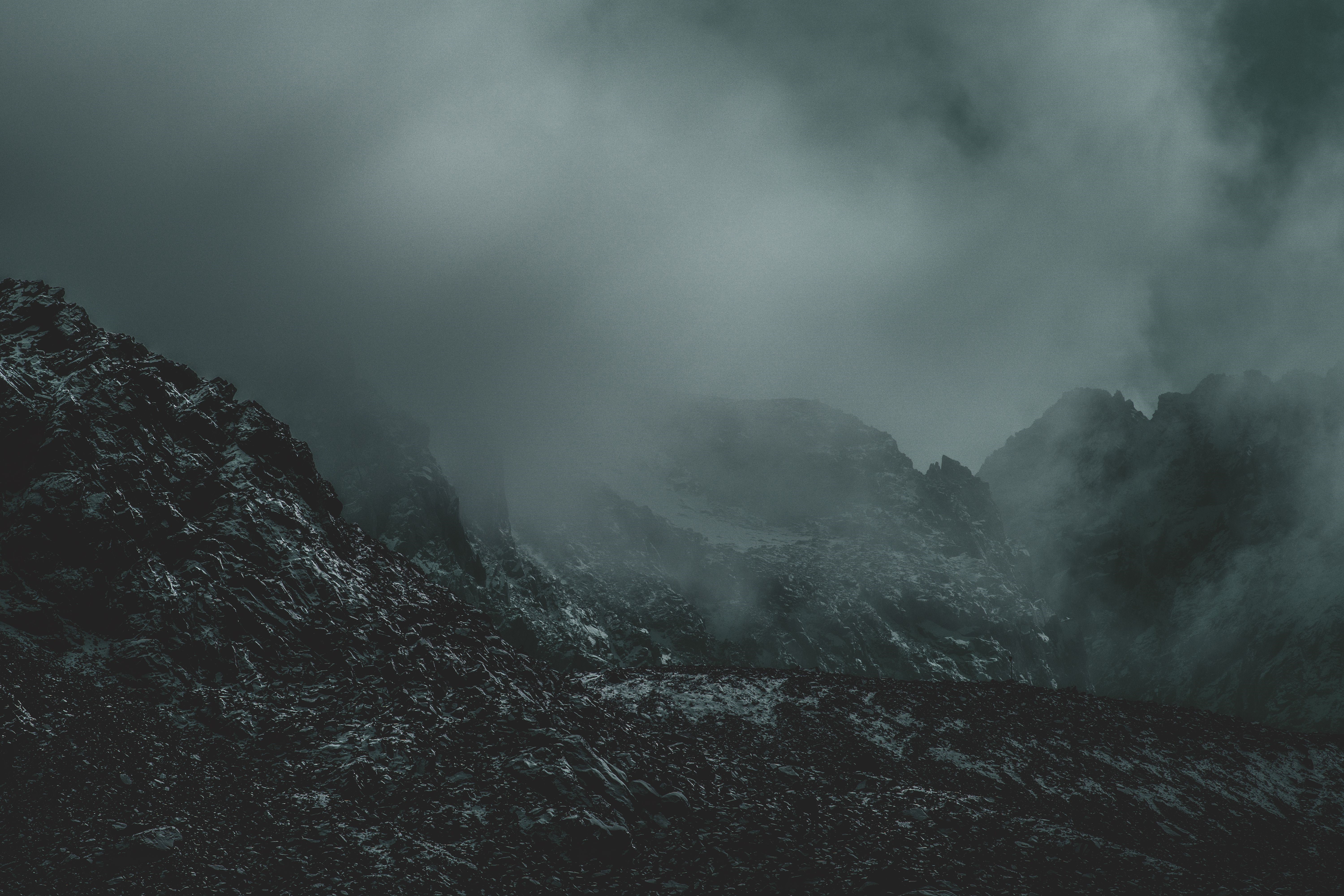Misty mountains with rocky terrain HD Wallpaper