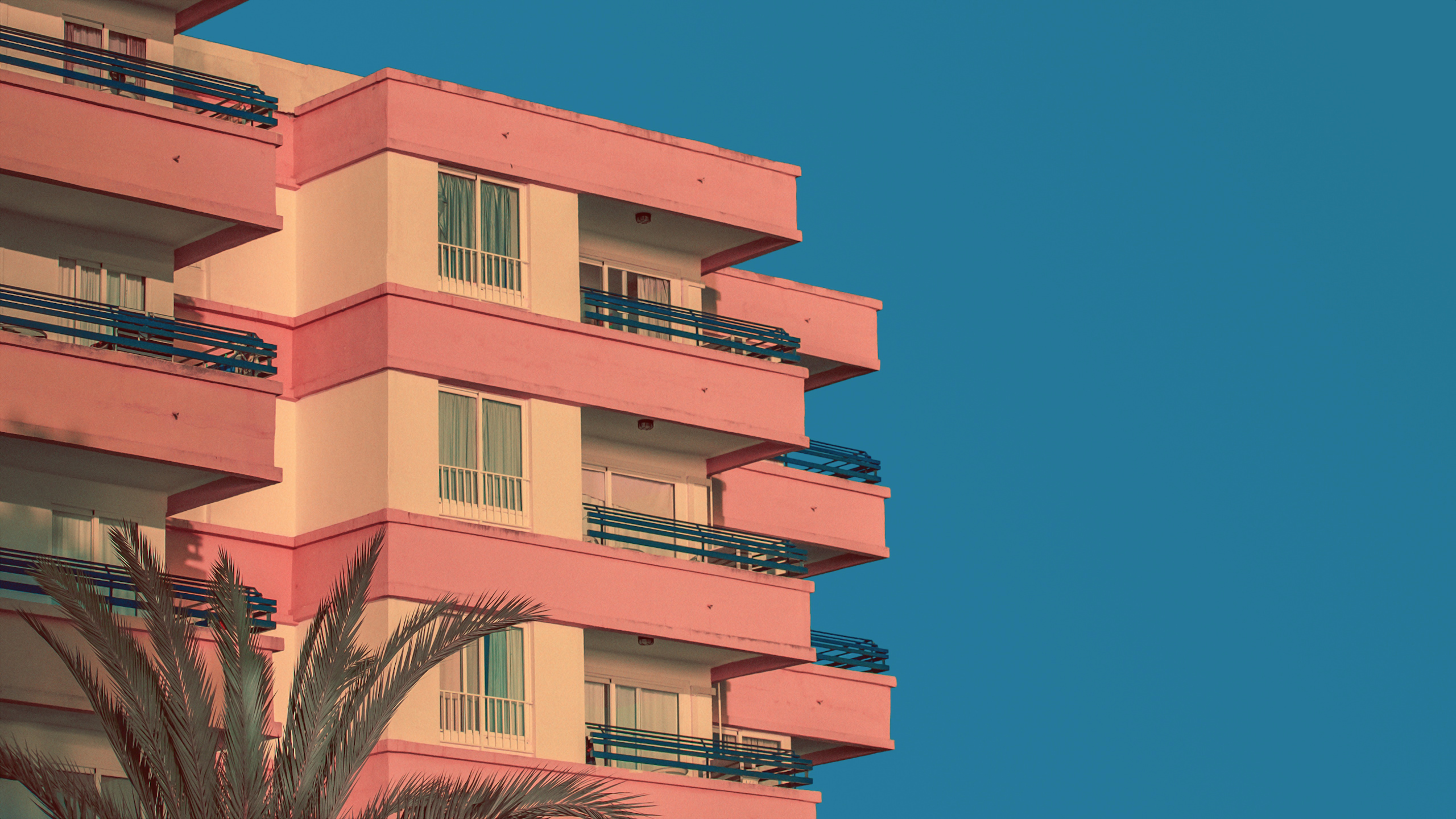 Pink and white building with balconies against blue sky HD Wallpaper
