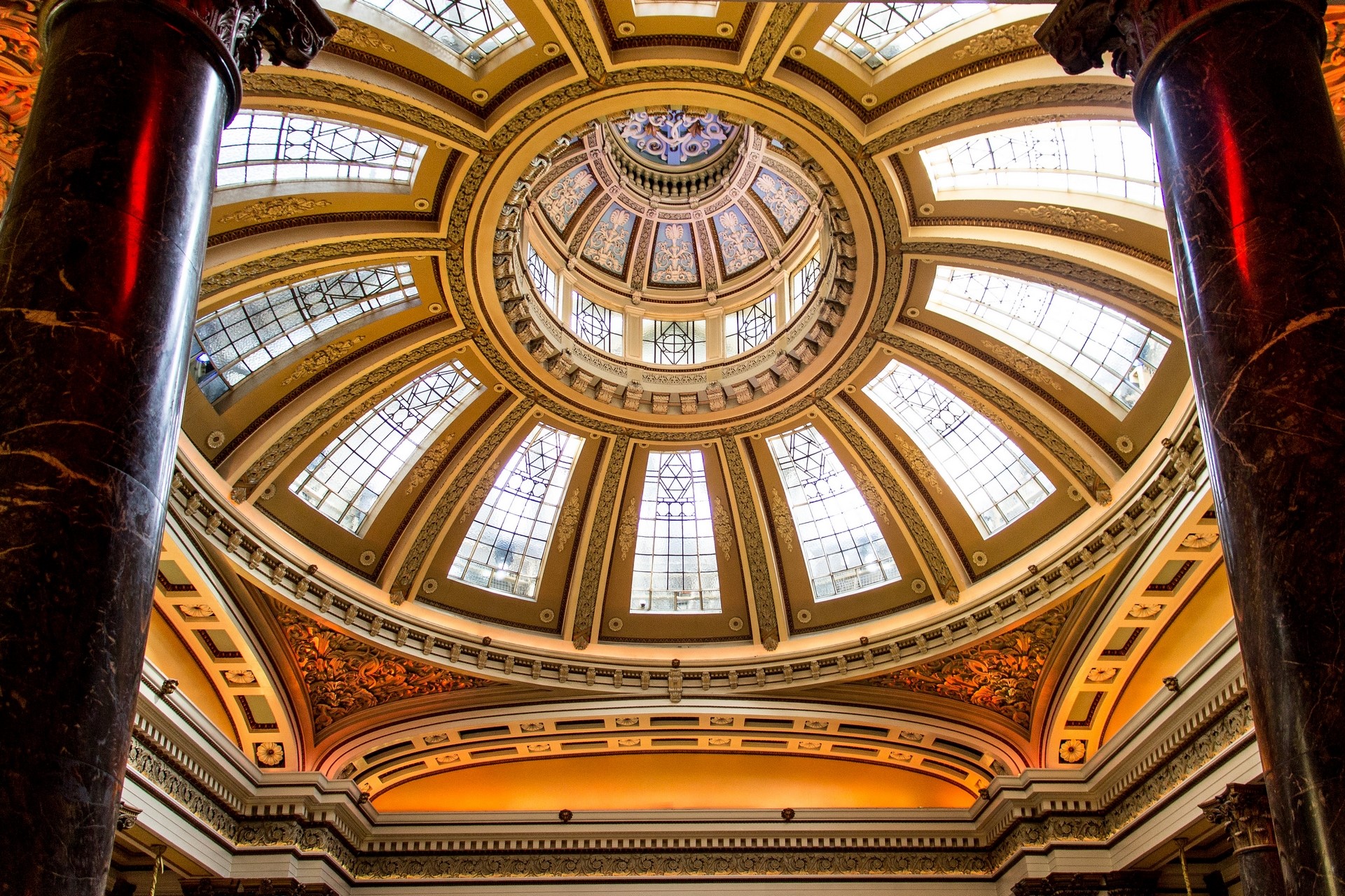 Interior of a grand dome with ornate architecture and stained glass windows HD Wallpaper