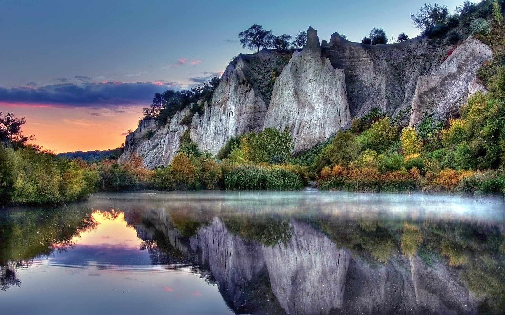 Cliff formations reflected in a misty lake at sunrise HD Wallpaper