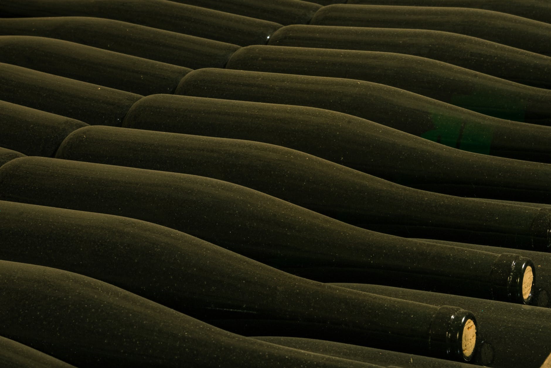 Dusty wine bottles stacked in cellar HD Wallpaper