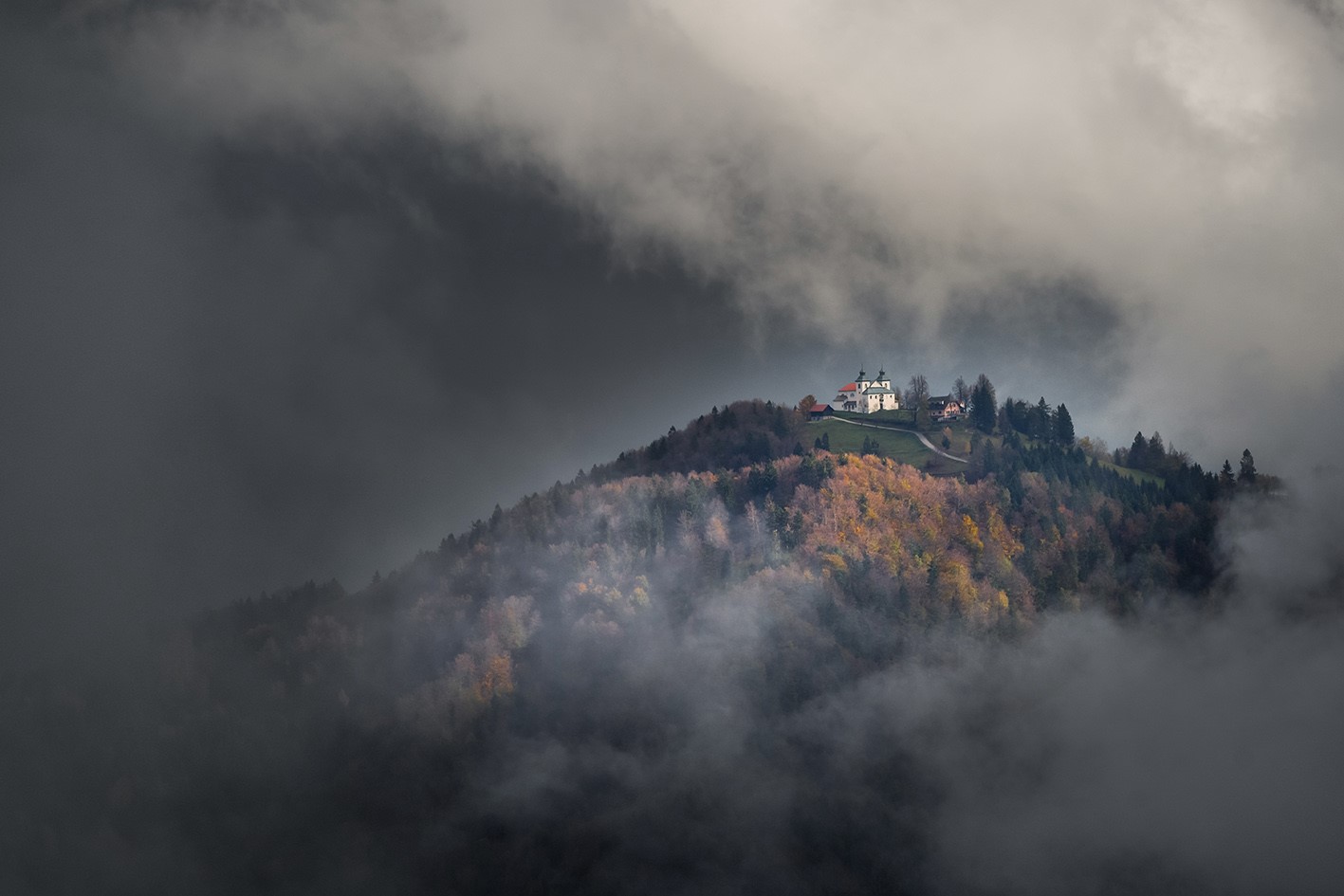 White building on a misty hill with autumn trees HD Wallpaper
