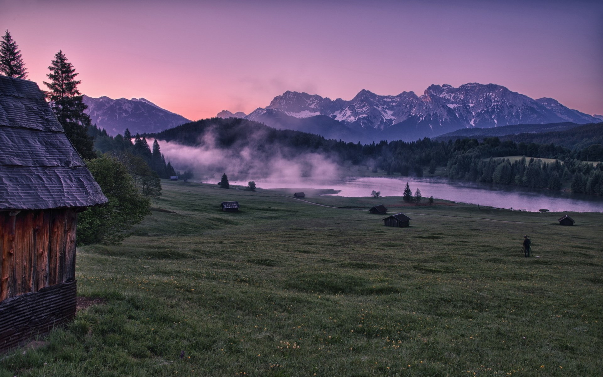 Wooden cabin and misty lake at sunrise with mountains HD Wallpaper