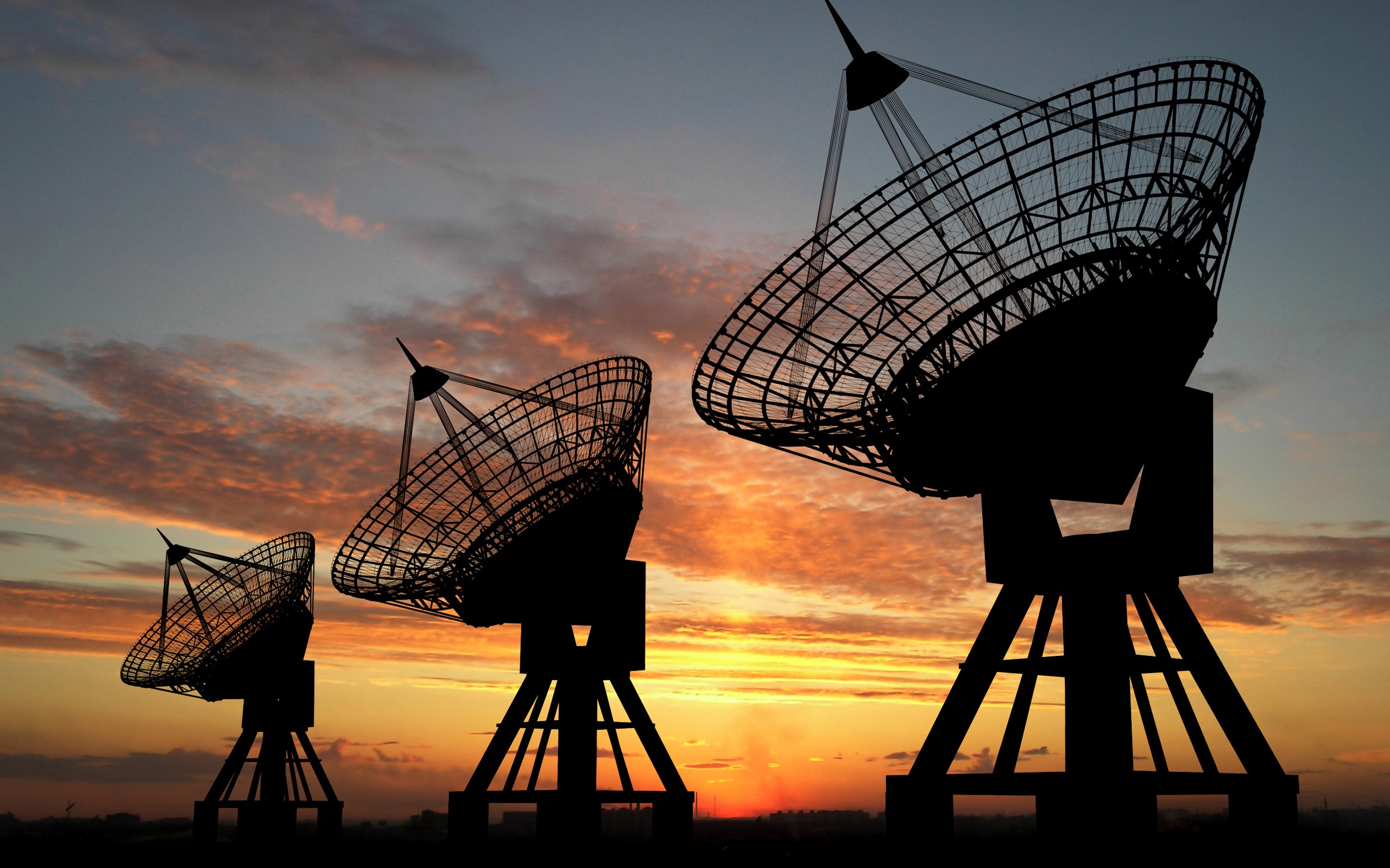 Radio telescopes silhouetted against a sunset sky HD Wallpaper