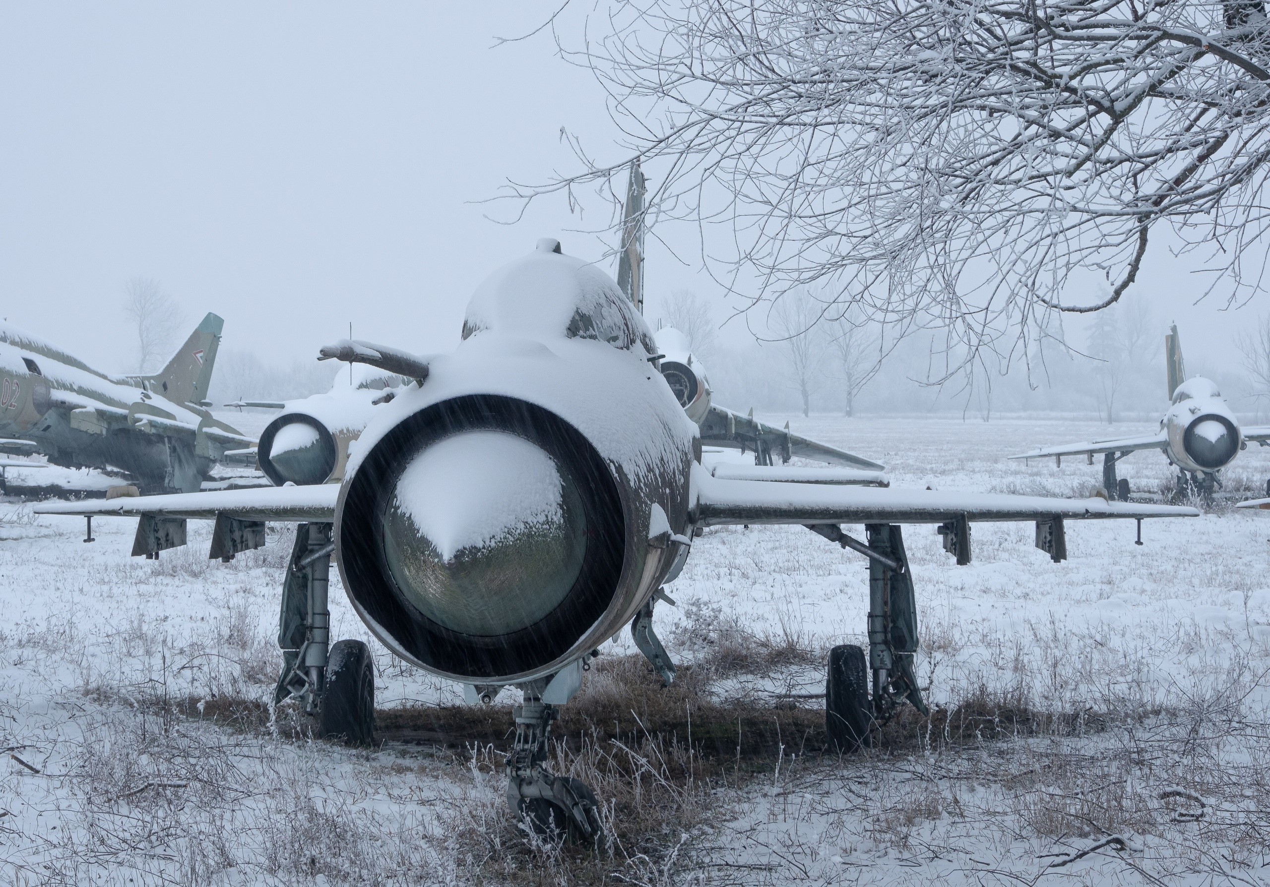 MiG-21 fighter jets covered in snow in a field HD Wallpaper