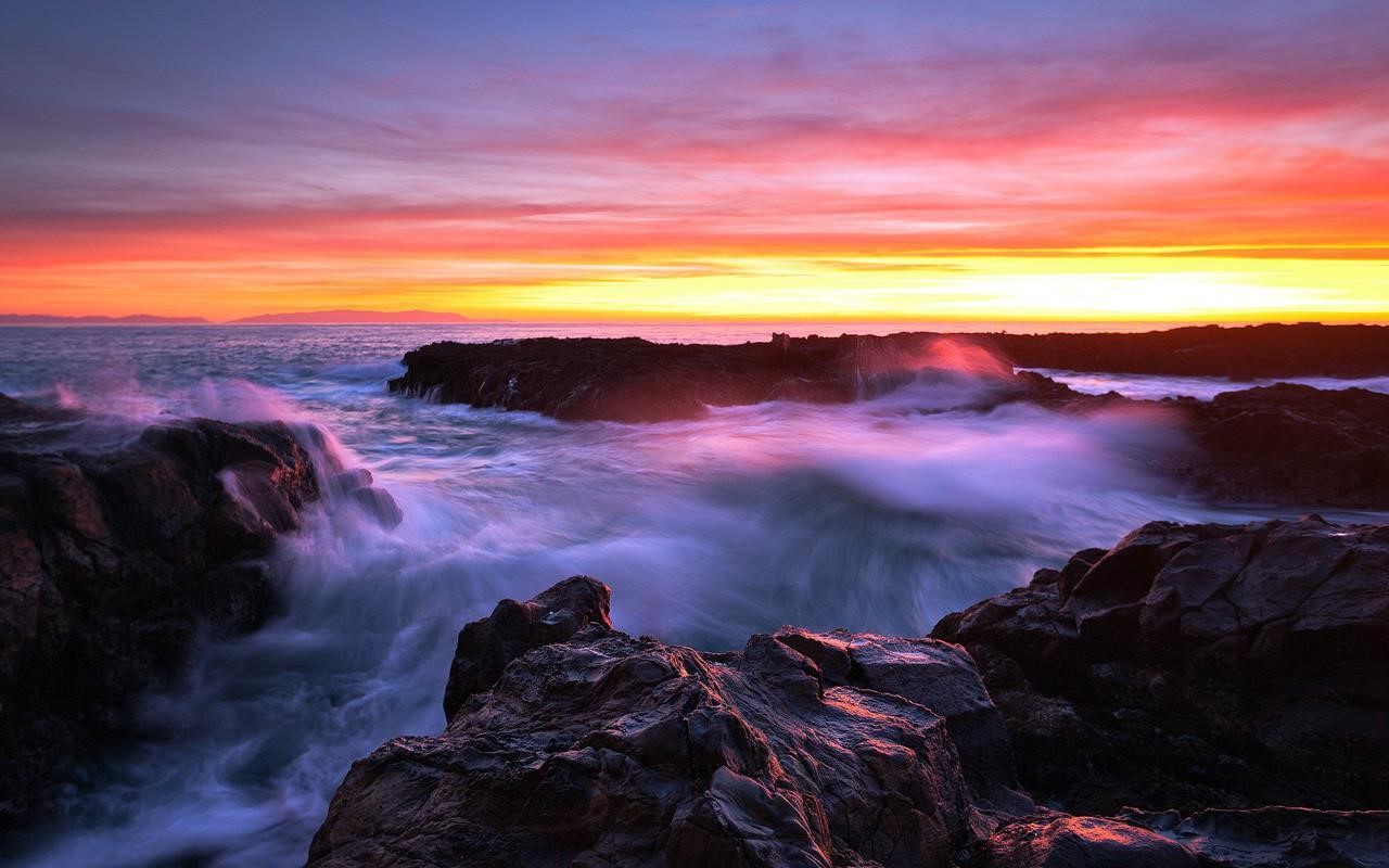 Sunset over rocky coast with crashing waves HD Wallpaper