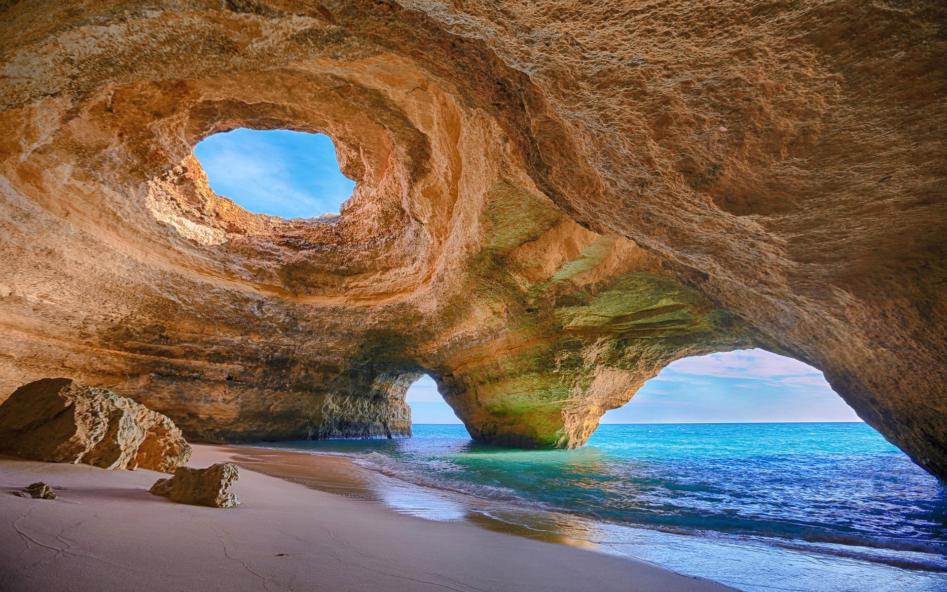 Cave opening with ocean view and sandy beach HD Wallpaper
