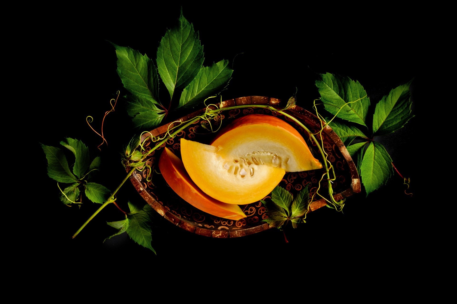 Slices of pumpkin with leaves on a dark background HD Wallpaper