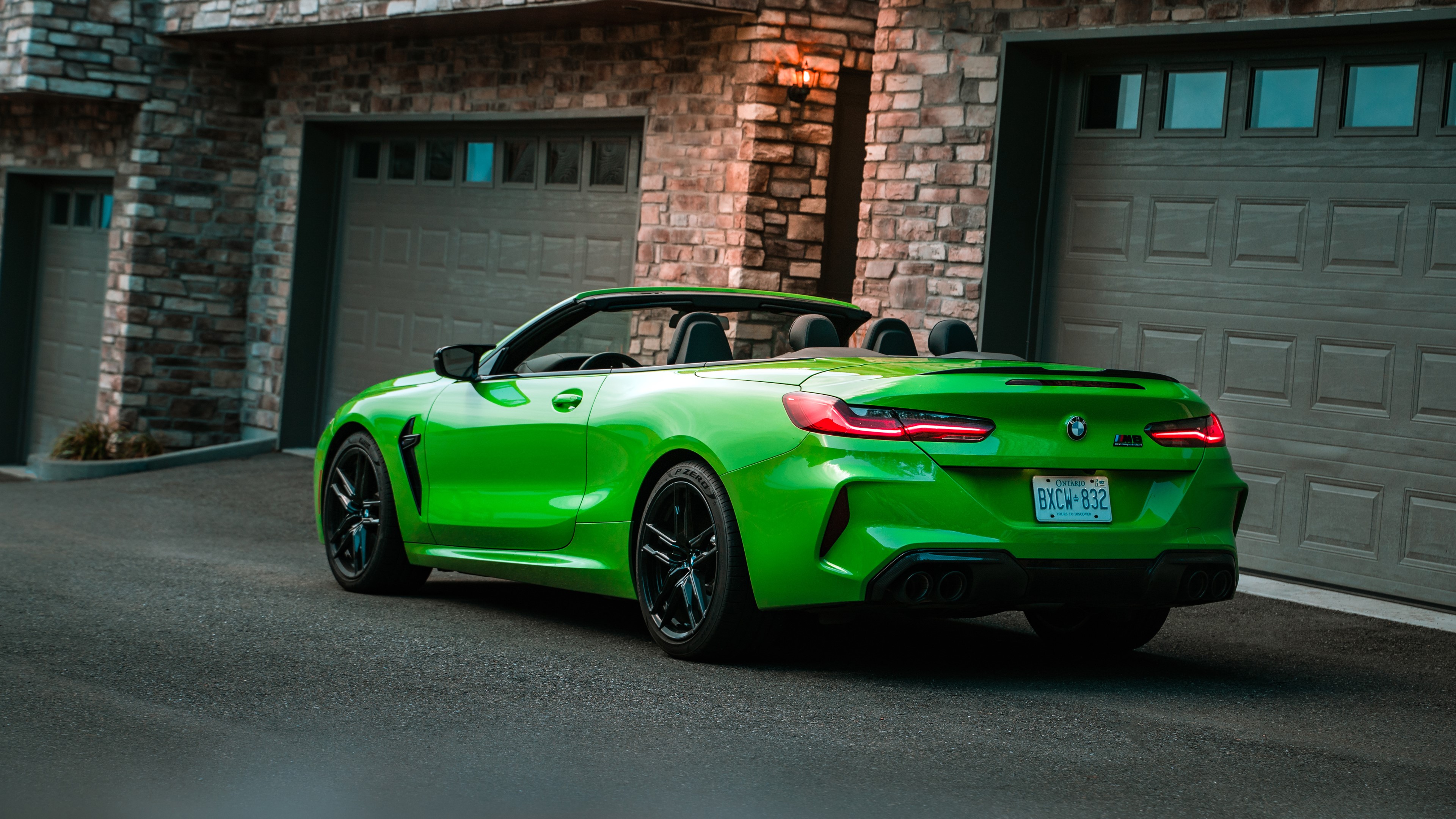 Green BMW M8 Convertible parked in front of a garage HD Wallpaper