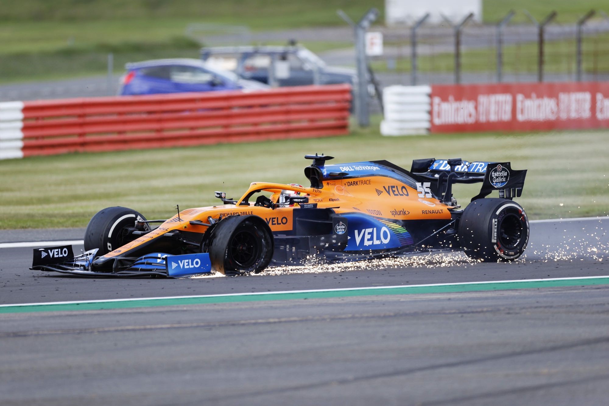 Carlos Sainz Jr. in a McLaren F1 car on a race track HD Wallpaper