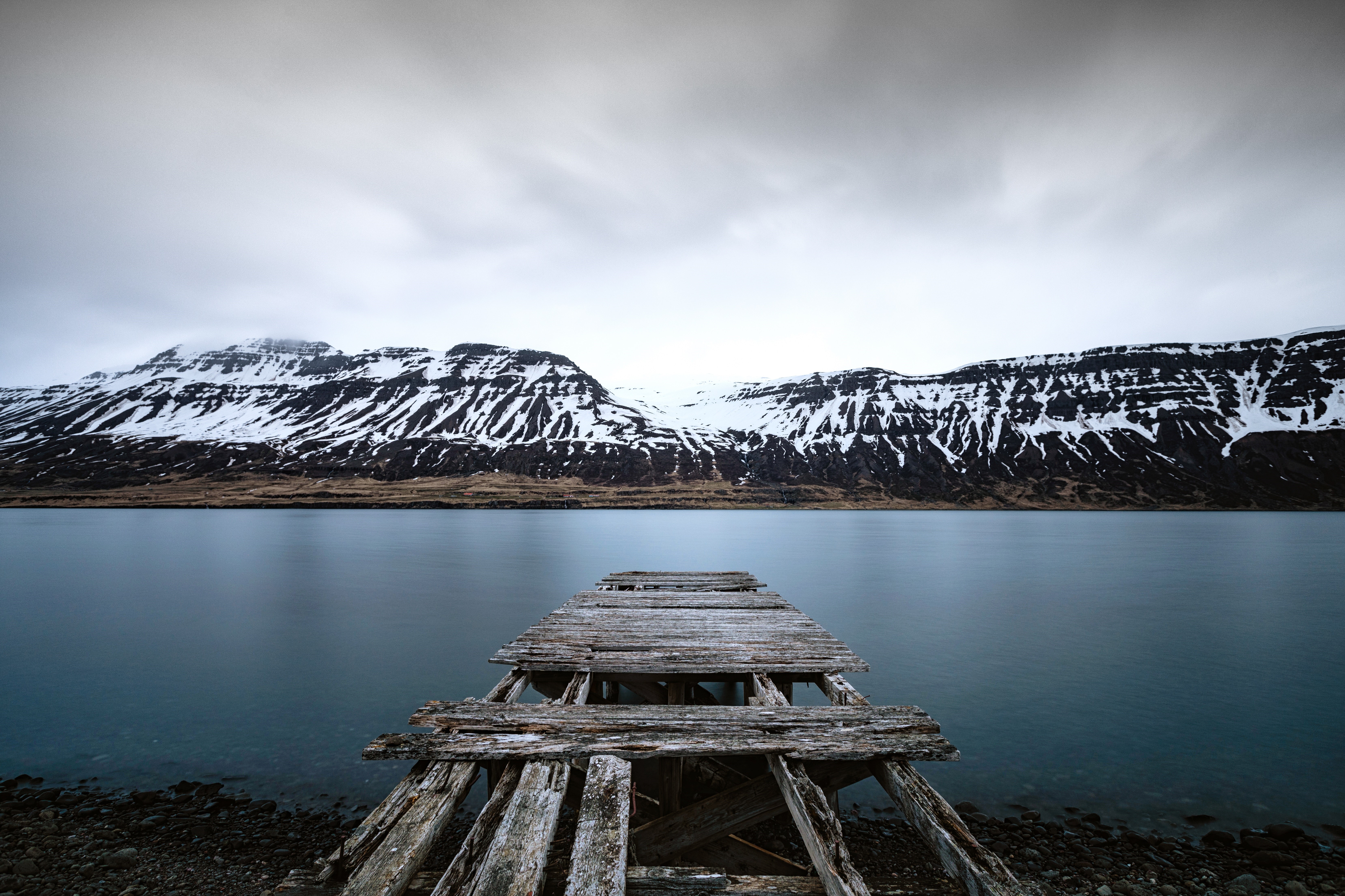 Old wooden pier on a lake with snow-capped mountains HD Wallpaper