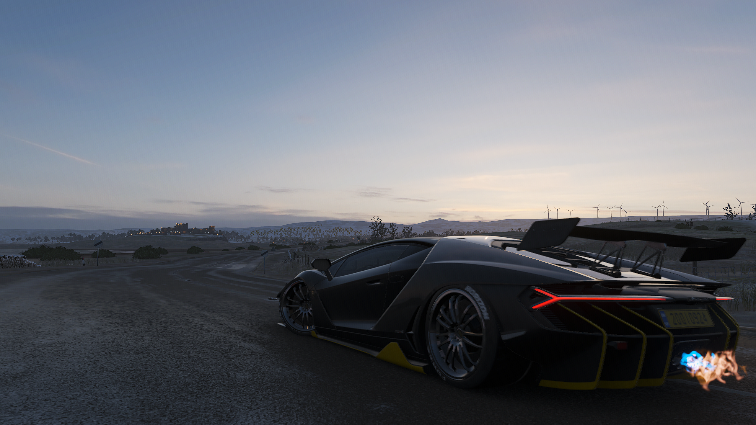 Black sports car with flames coming out of exhaust on a dirt road HD Wallpaper