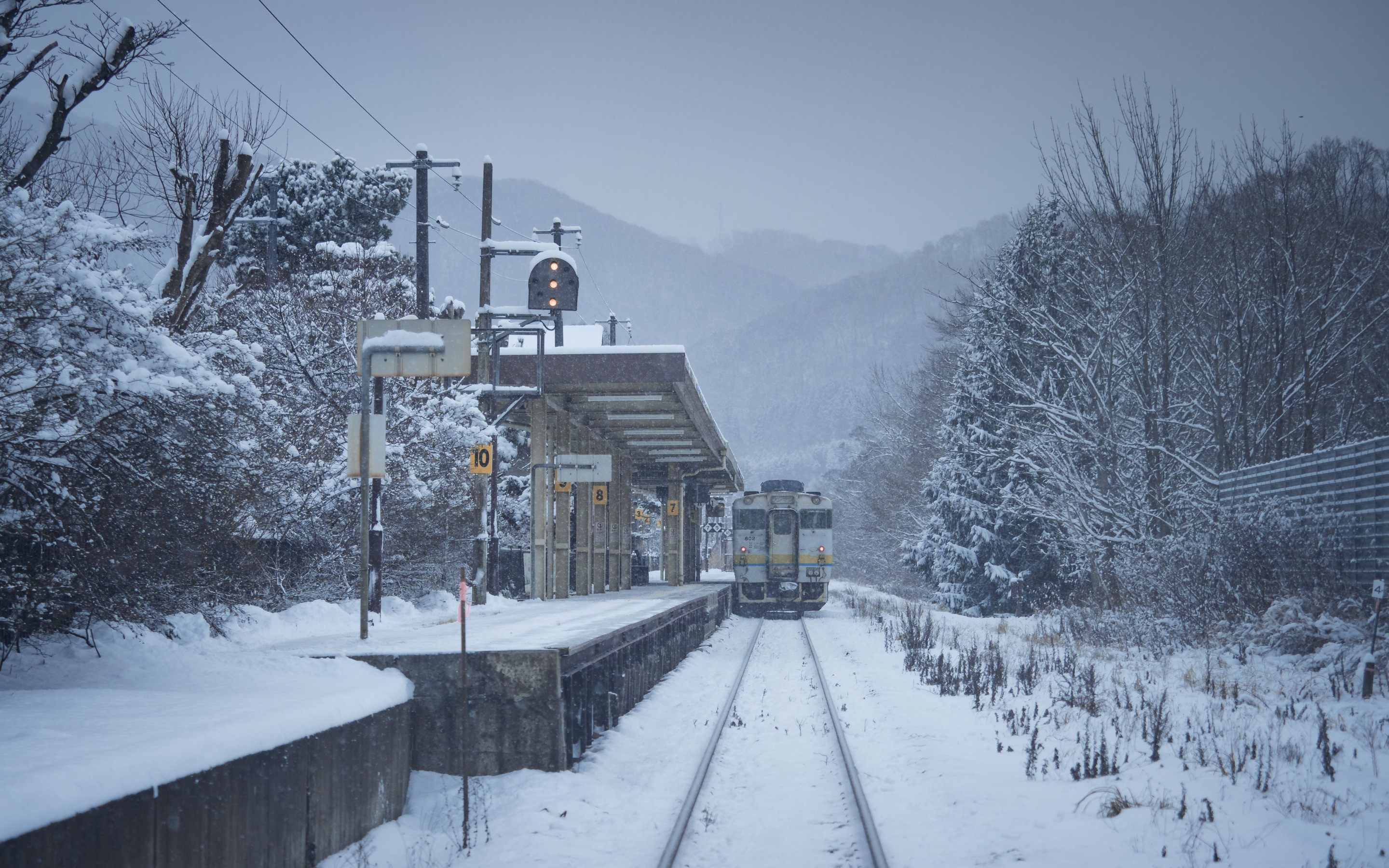Train at a snowy station in the mountains HD Wallpaper
