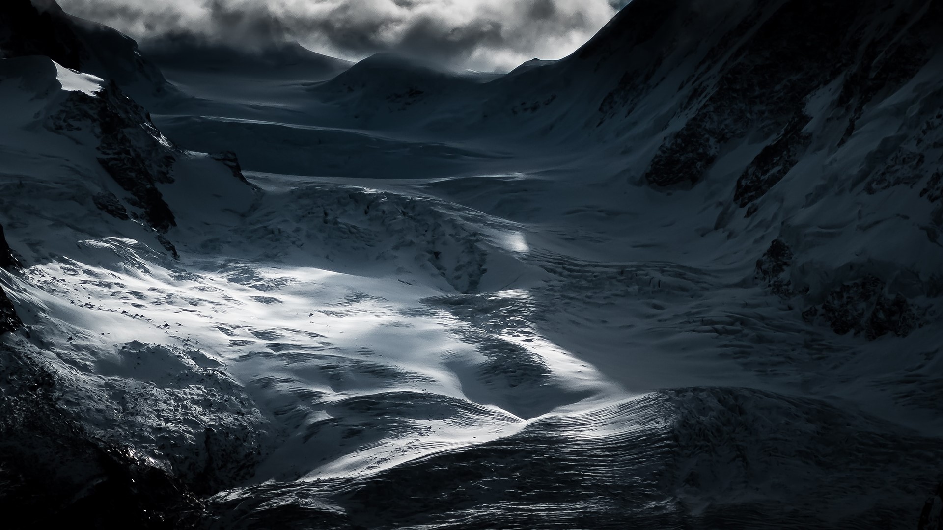 Snowy mountains under dramatic clouds HD Wallpaper