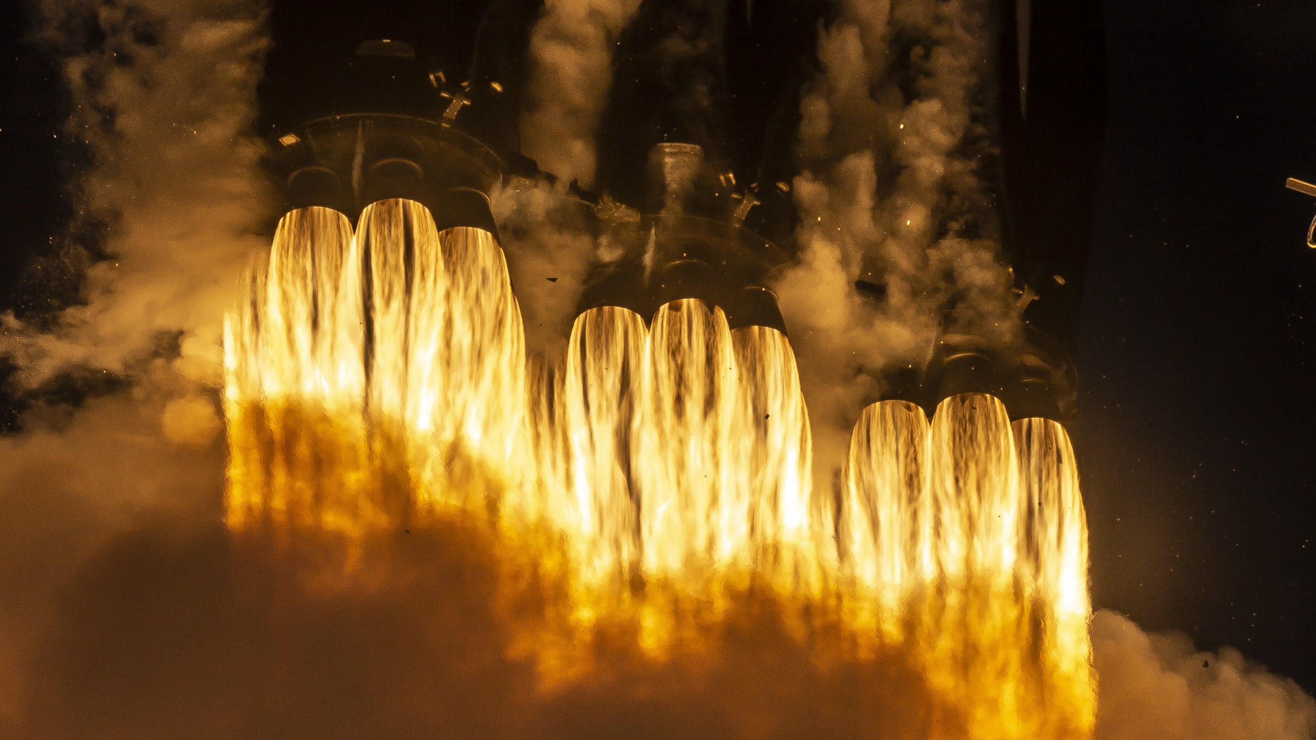 Rocket engines firing with bright yellow flames and smoke HD Wallpaper