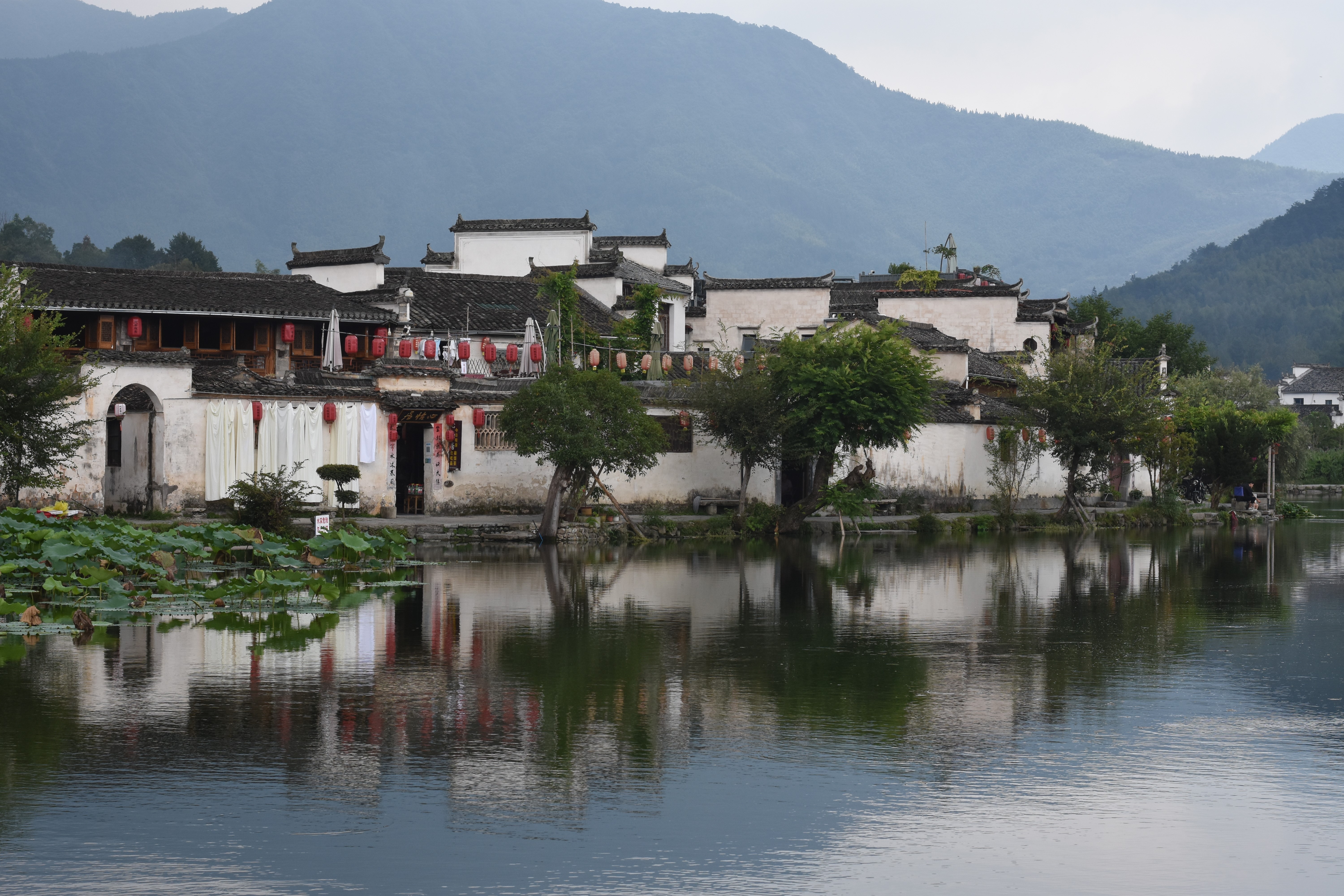Traditional Chinese architecture by a lake with mountains HD Wallpaper
