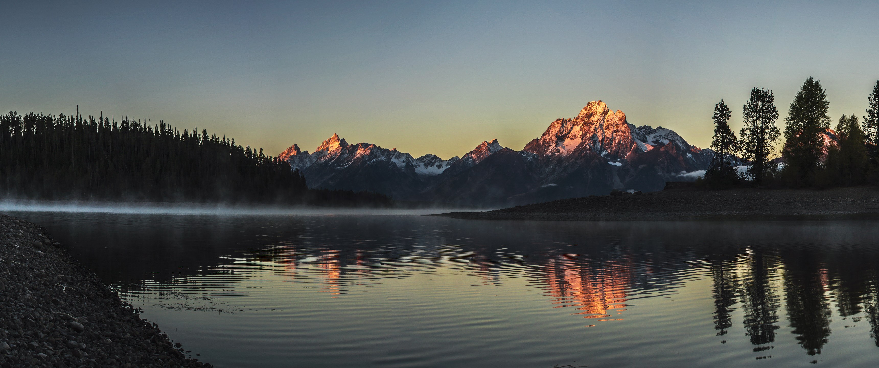 Sunrise over mountains reflected in a lake with mist HD Wallpaper
