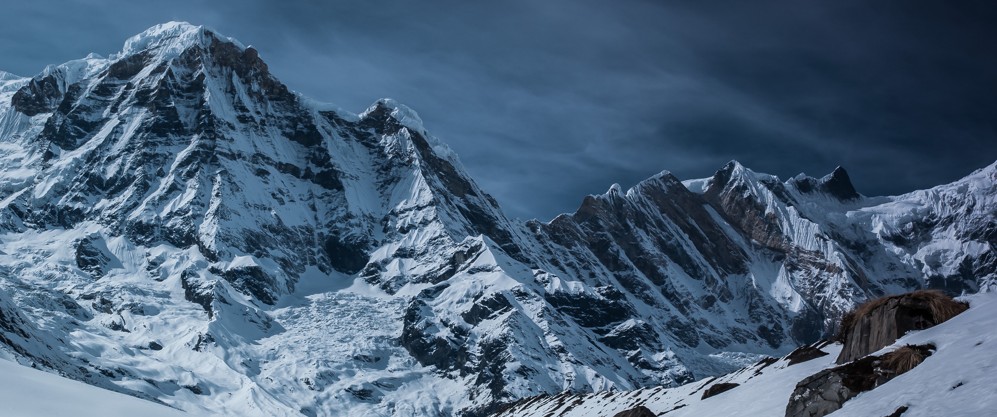 Snowy mountain range under a dark sky HD Wallpaper