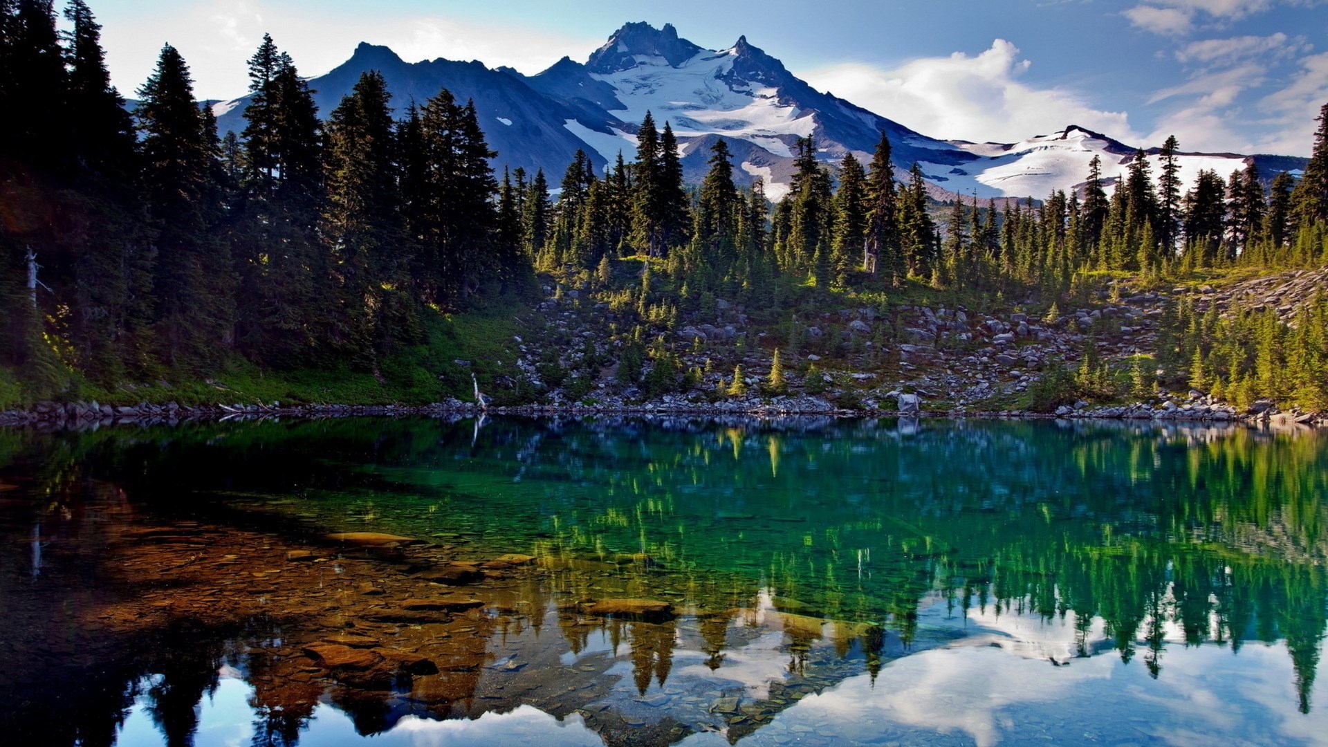 Mountain lake with reflection of snow-capped mountains and pine trees HD Wallpaper