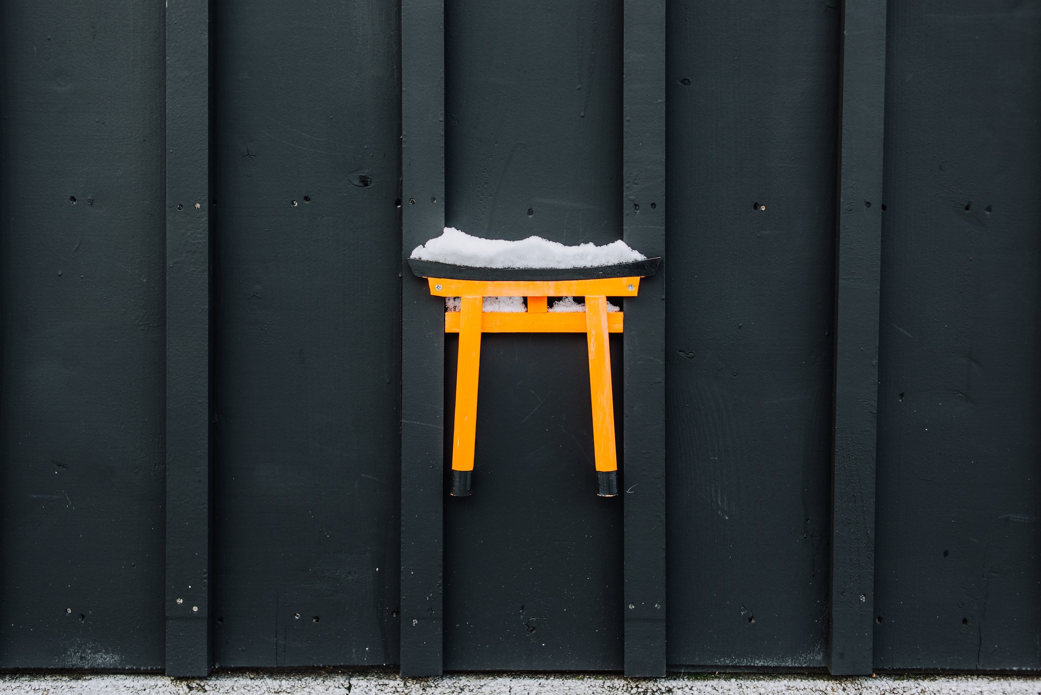 Orange Torii gate with snow on a dark wooden wall HD Wallpaper