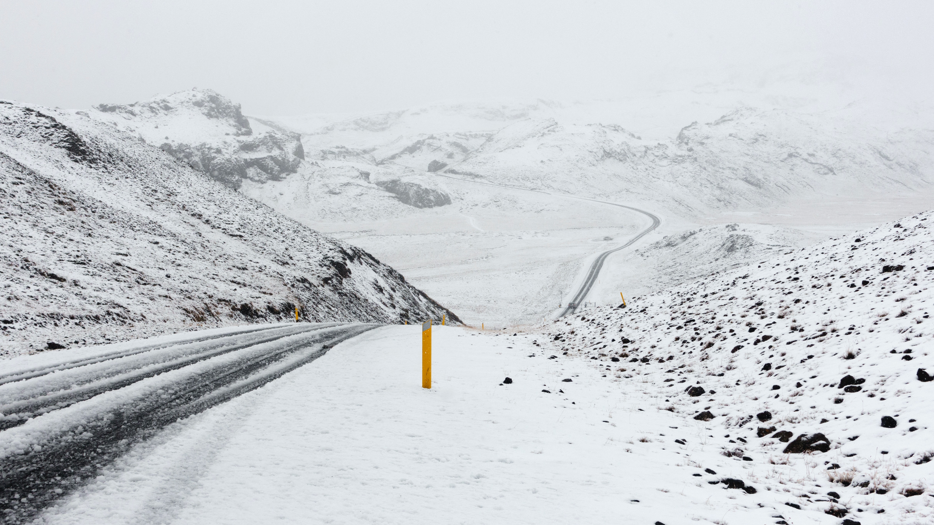 Snowy road through mountains in Iceland HD Wallpaper