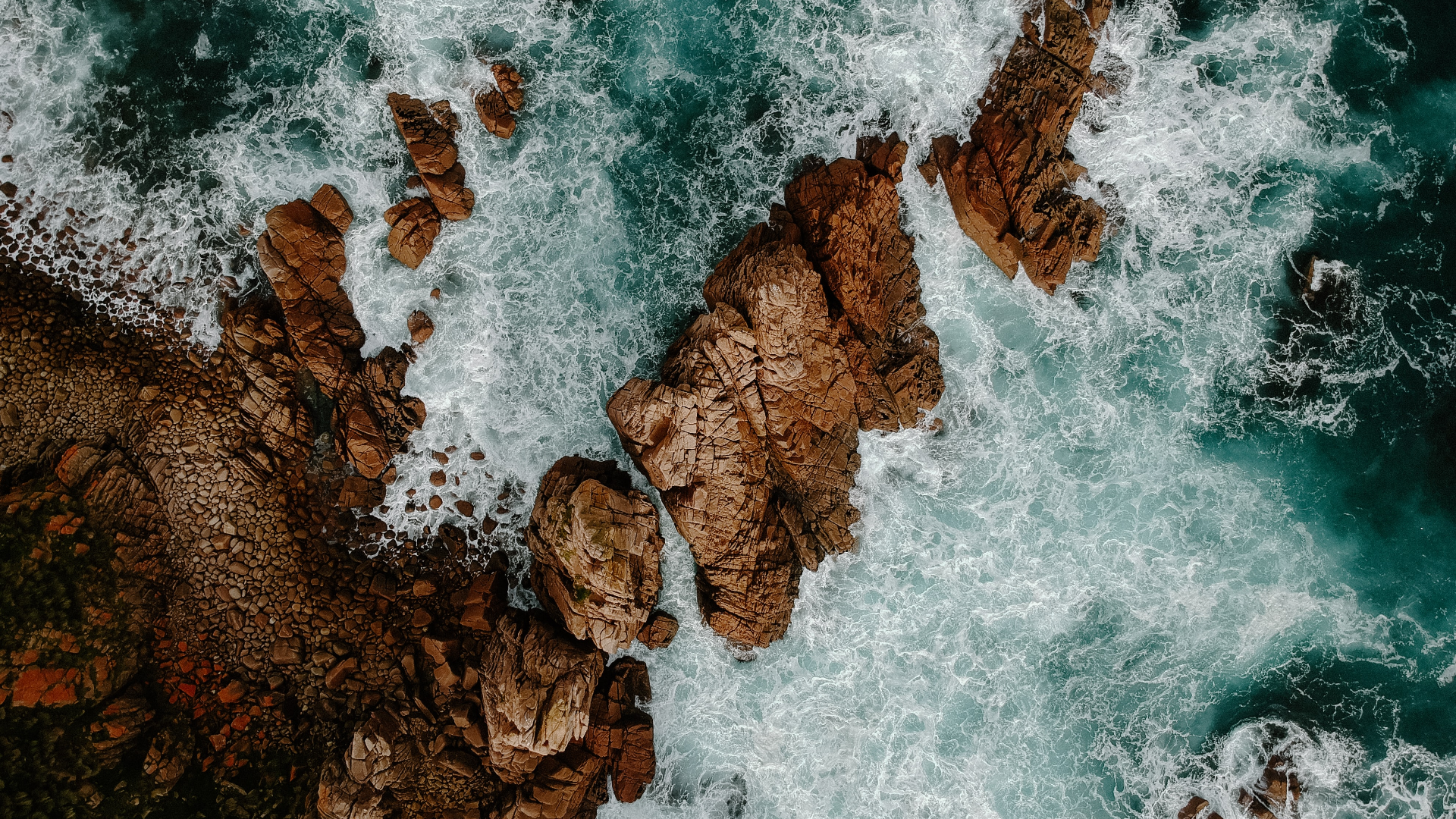 Aerial view of waves crashing on rocky coastline HD Wallpaper