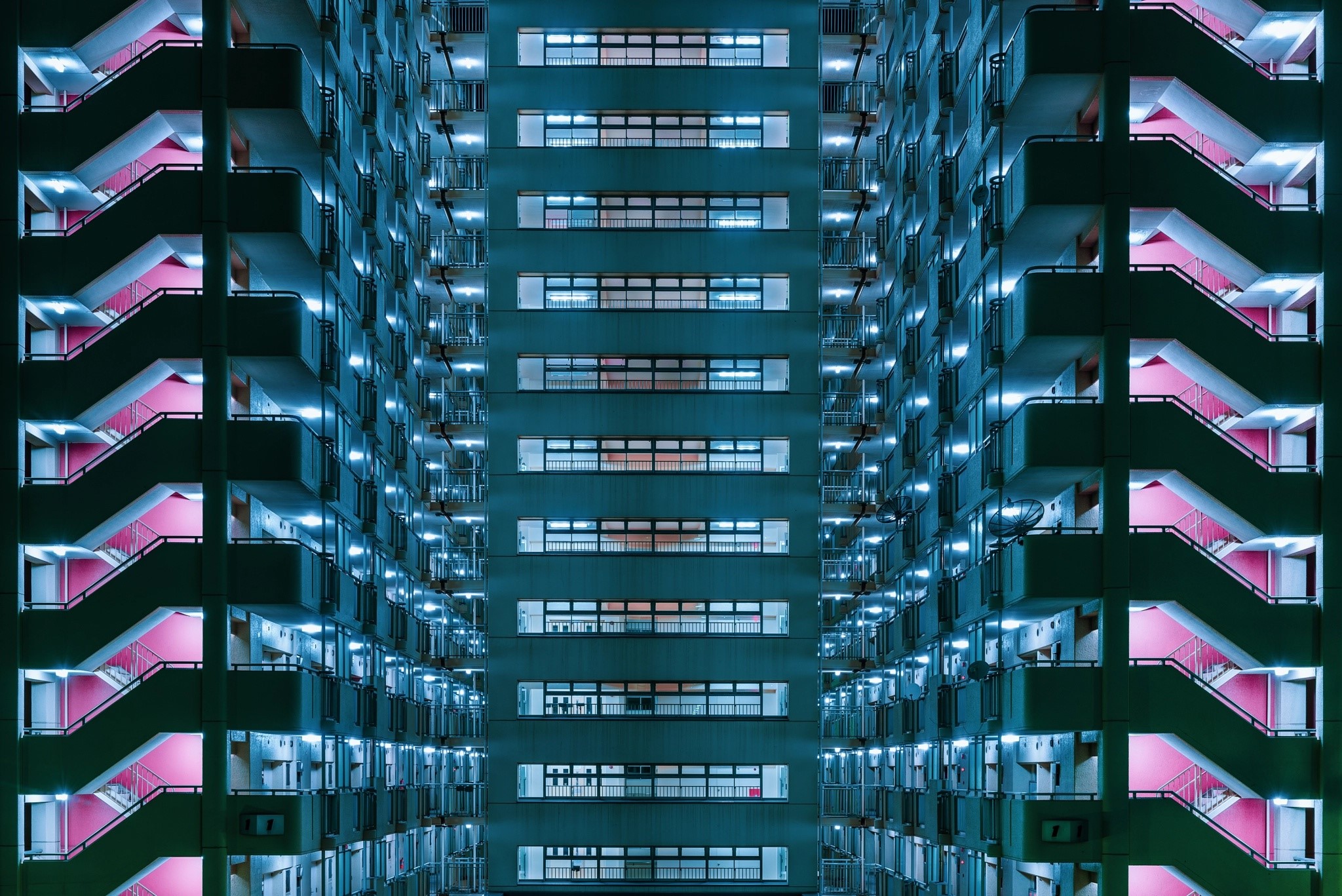 Symmetrical building with pink staircases at night HD Wallpaper