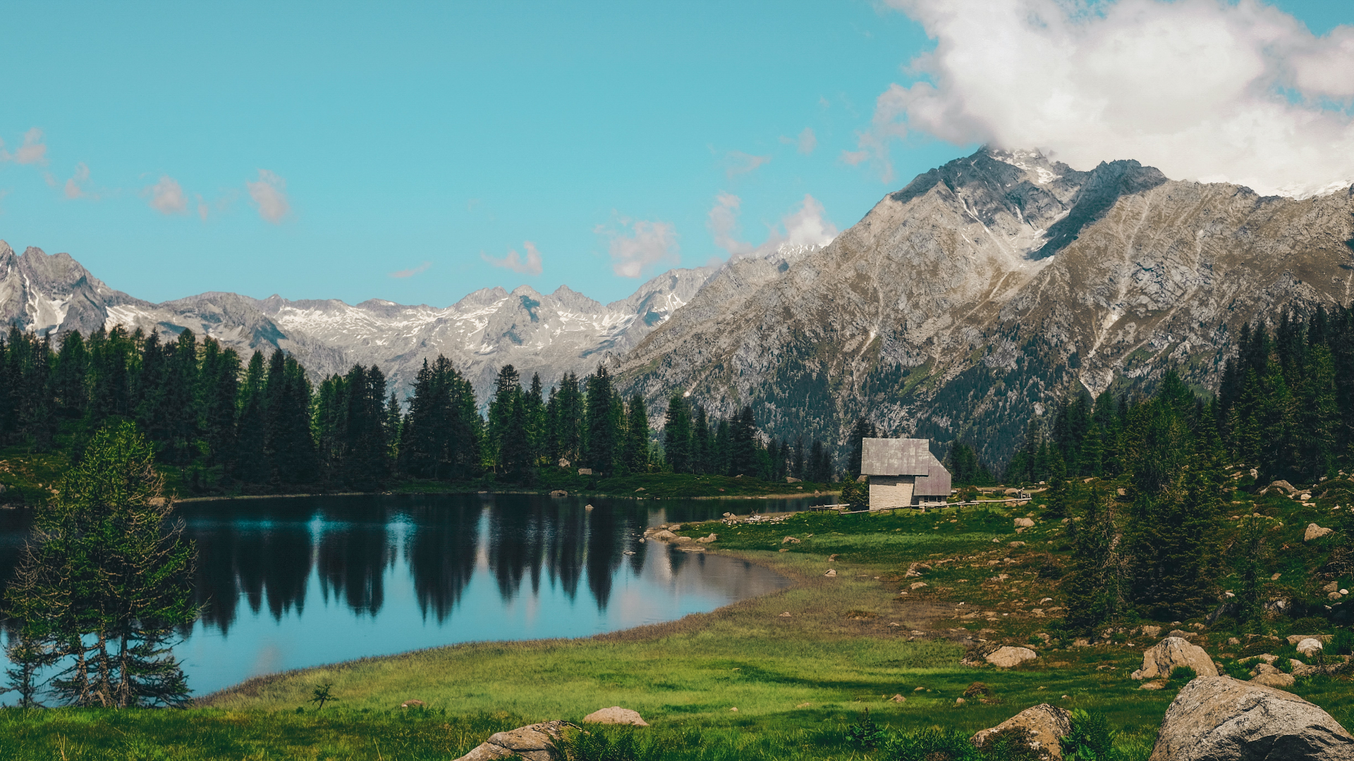 Lake and mountains with a small house HD Wallpaper