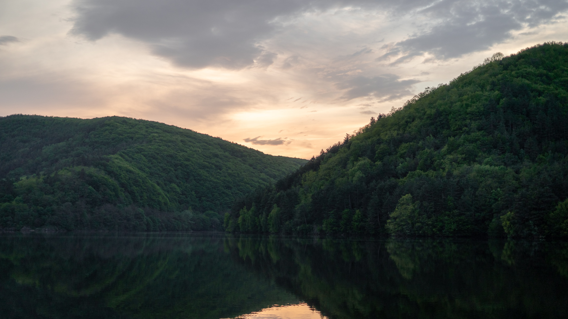 Green mountains reflected in a lake at dawn HD Wallpaper