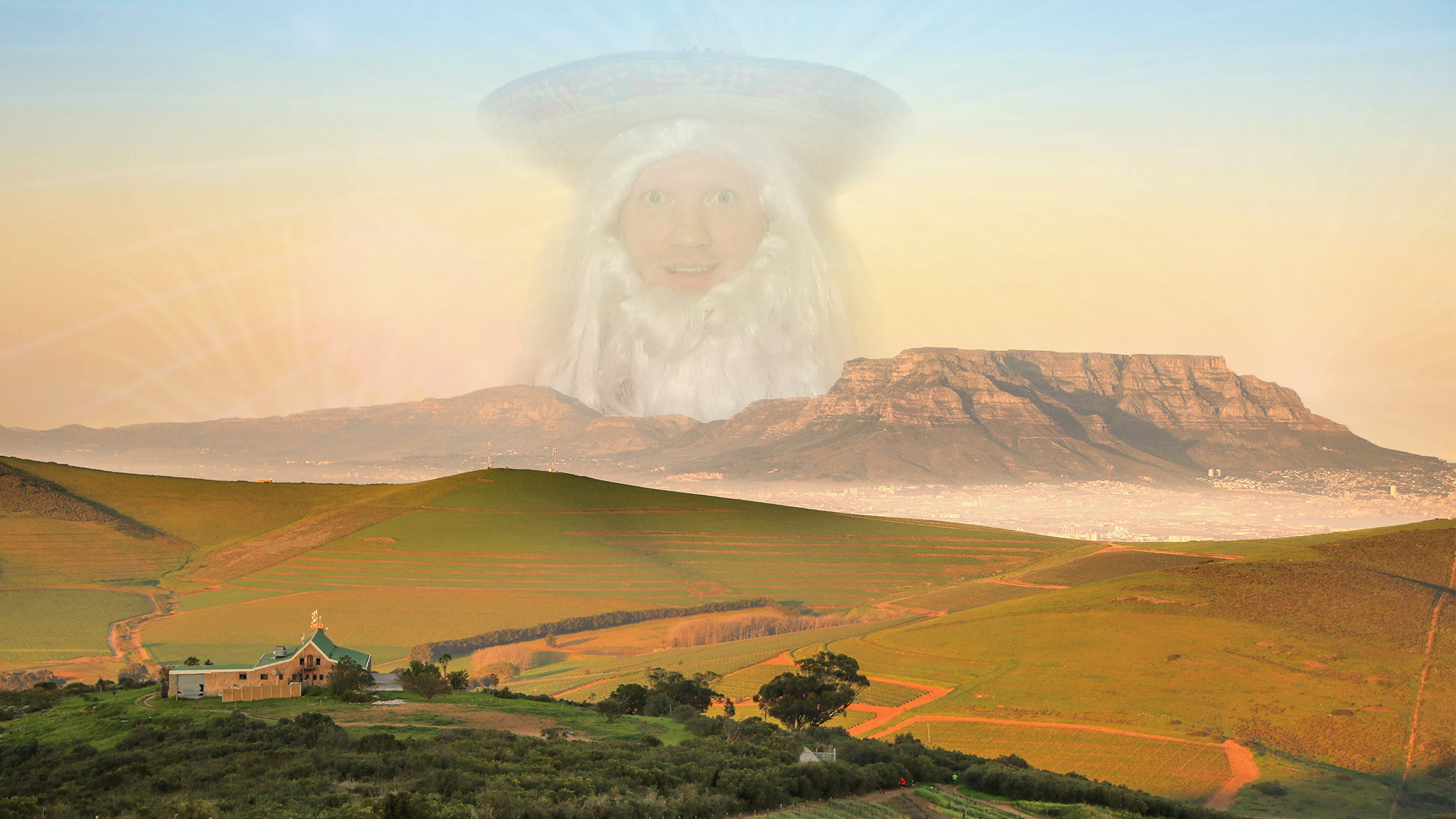 Giant man with beard and hat over mountains and farm HD Wallpaper