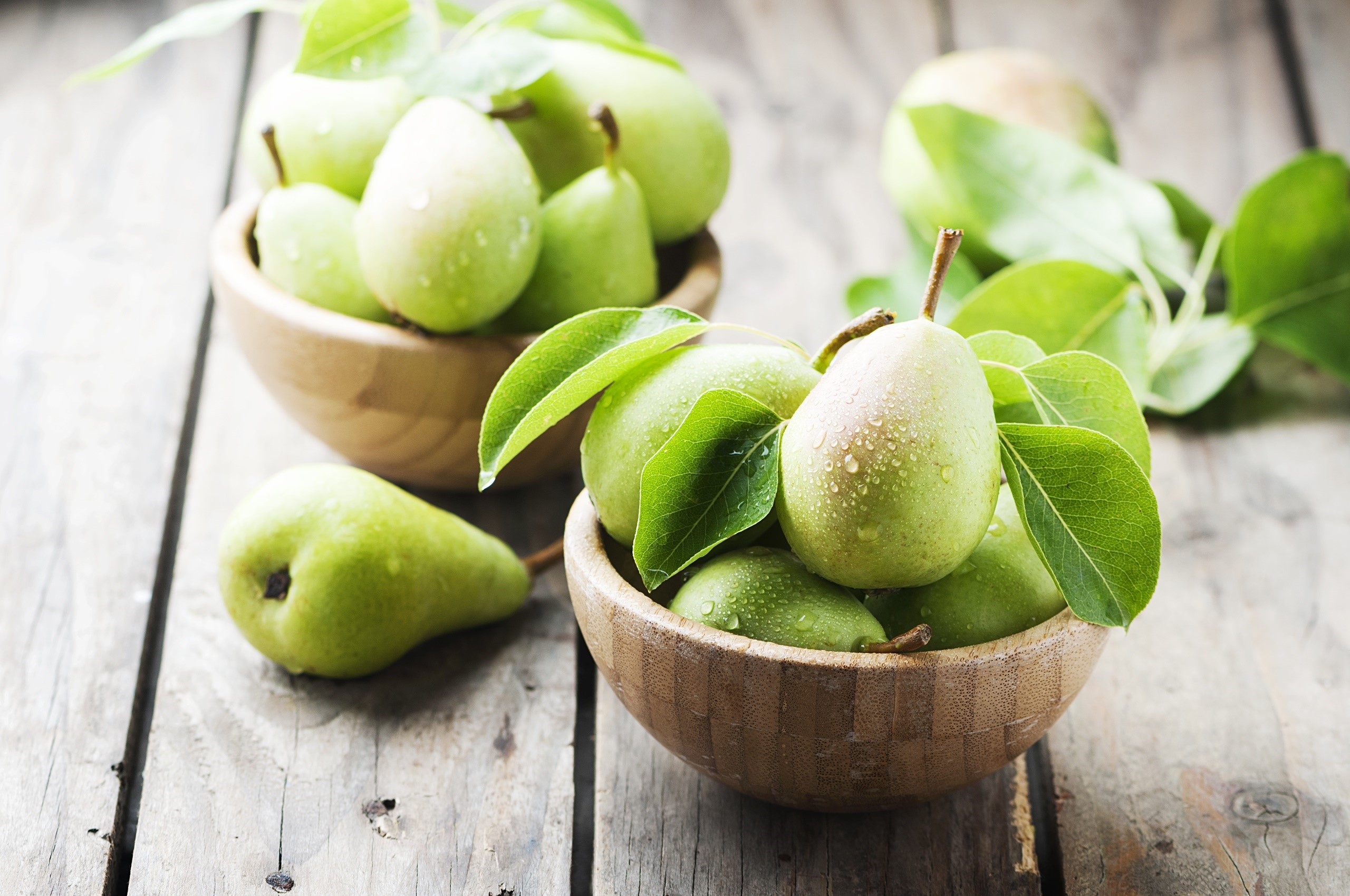 Green pears in wooden bowls on rustic table HD Wallpaper