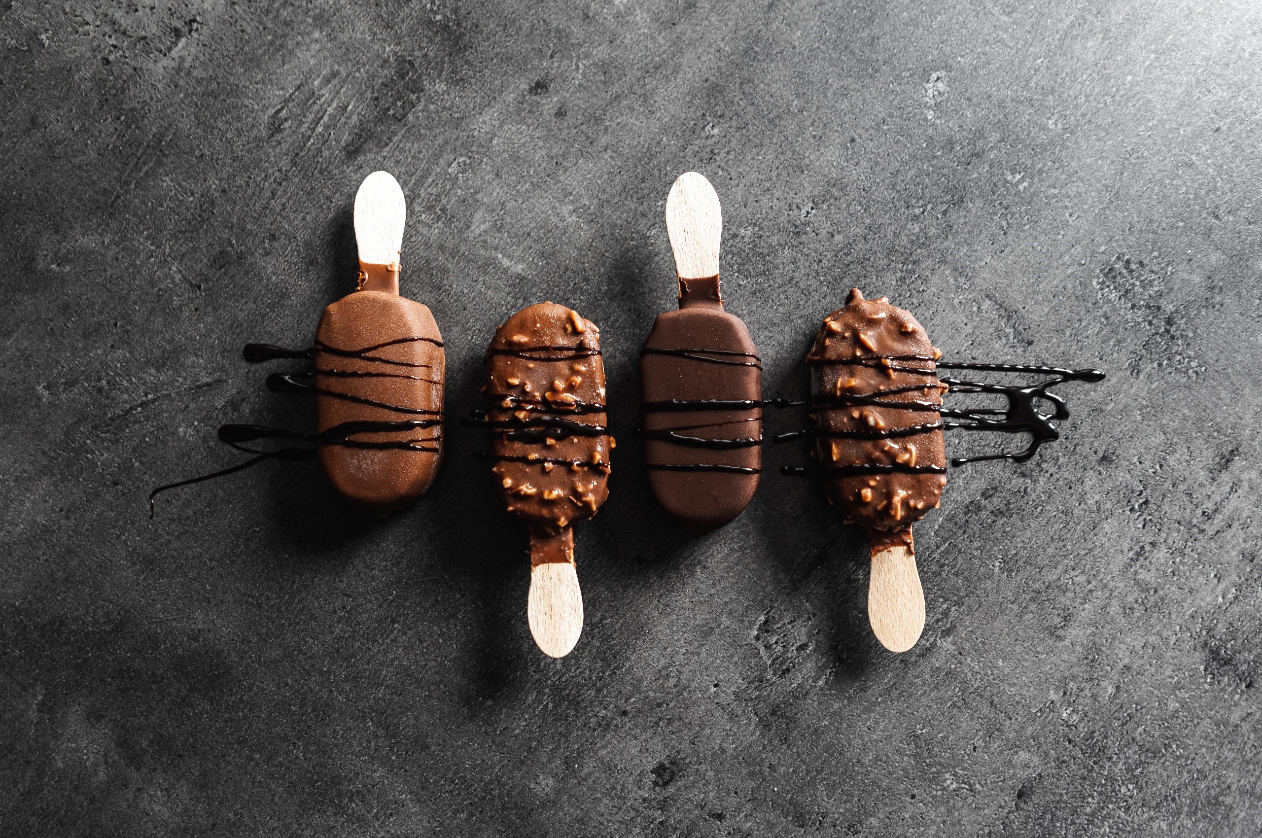 Four chocolate ice cream bars with chocolate drizzle HD Wallpaper