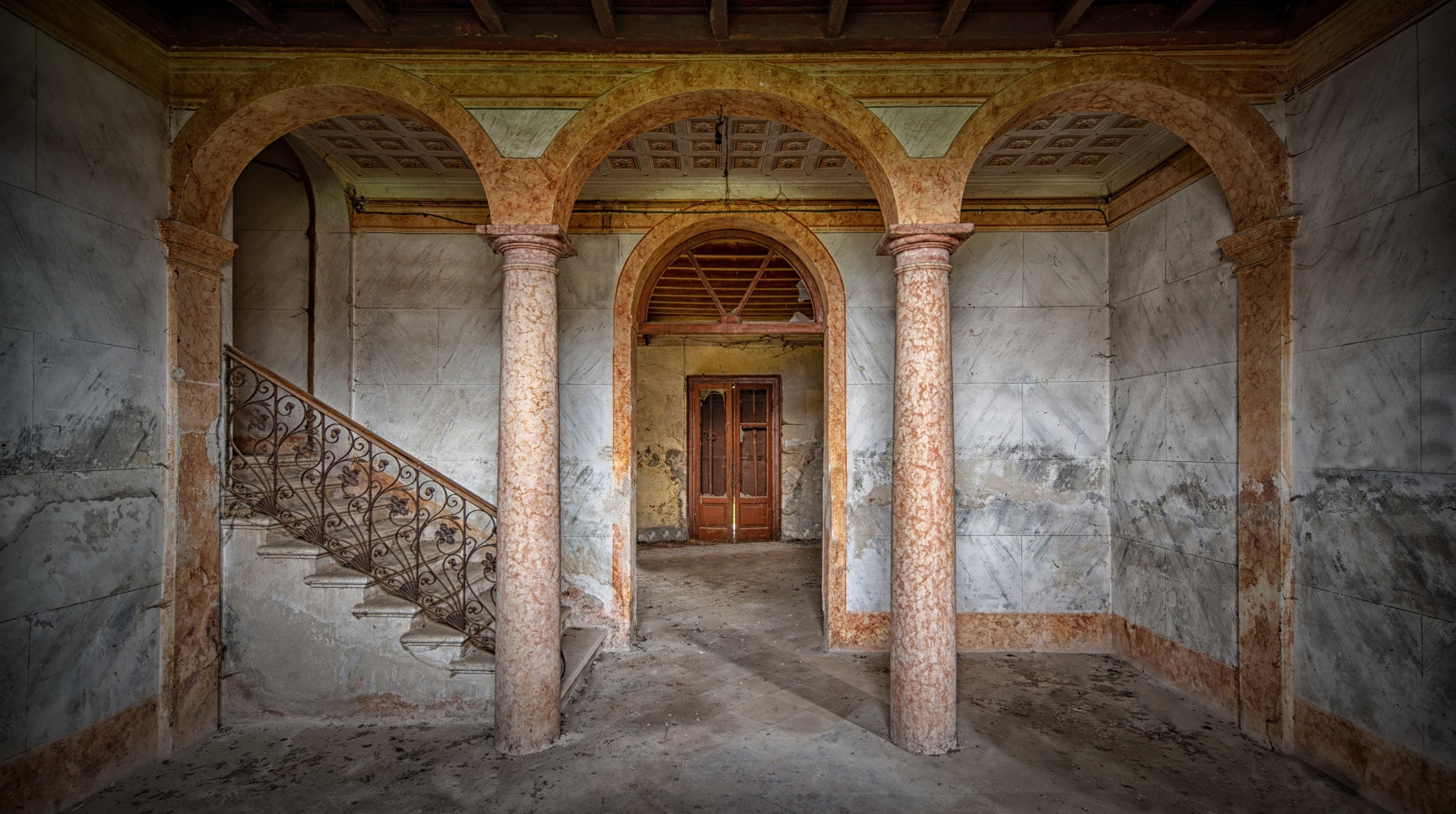 Abandoned building interior with arches and staircase HD Wallpaper