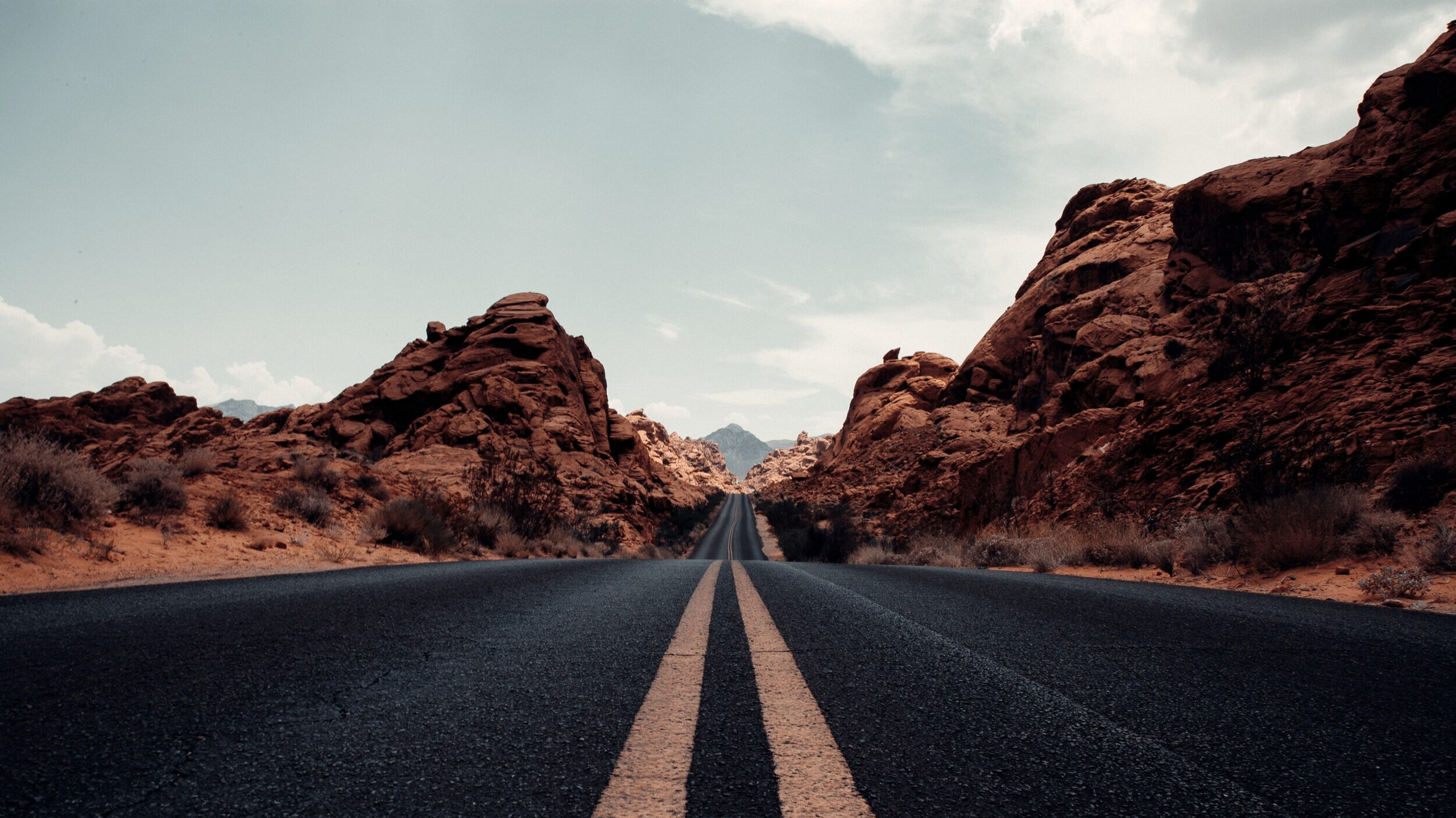 Asphalt road through rocky desert landscape HD Wallpaper