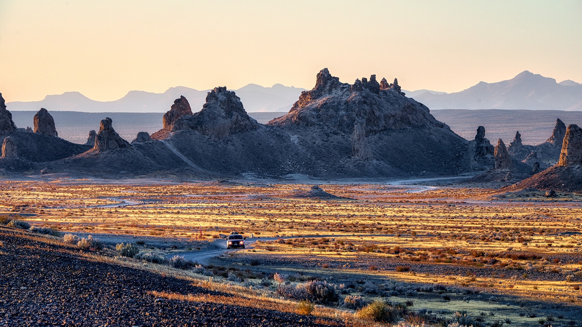 Desert landscape with rock formations and mountains HD Wallpaper