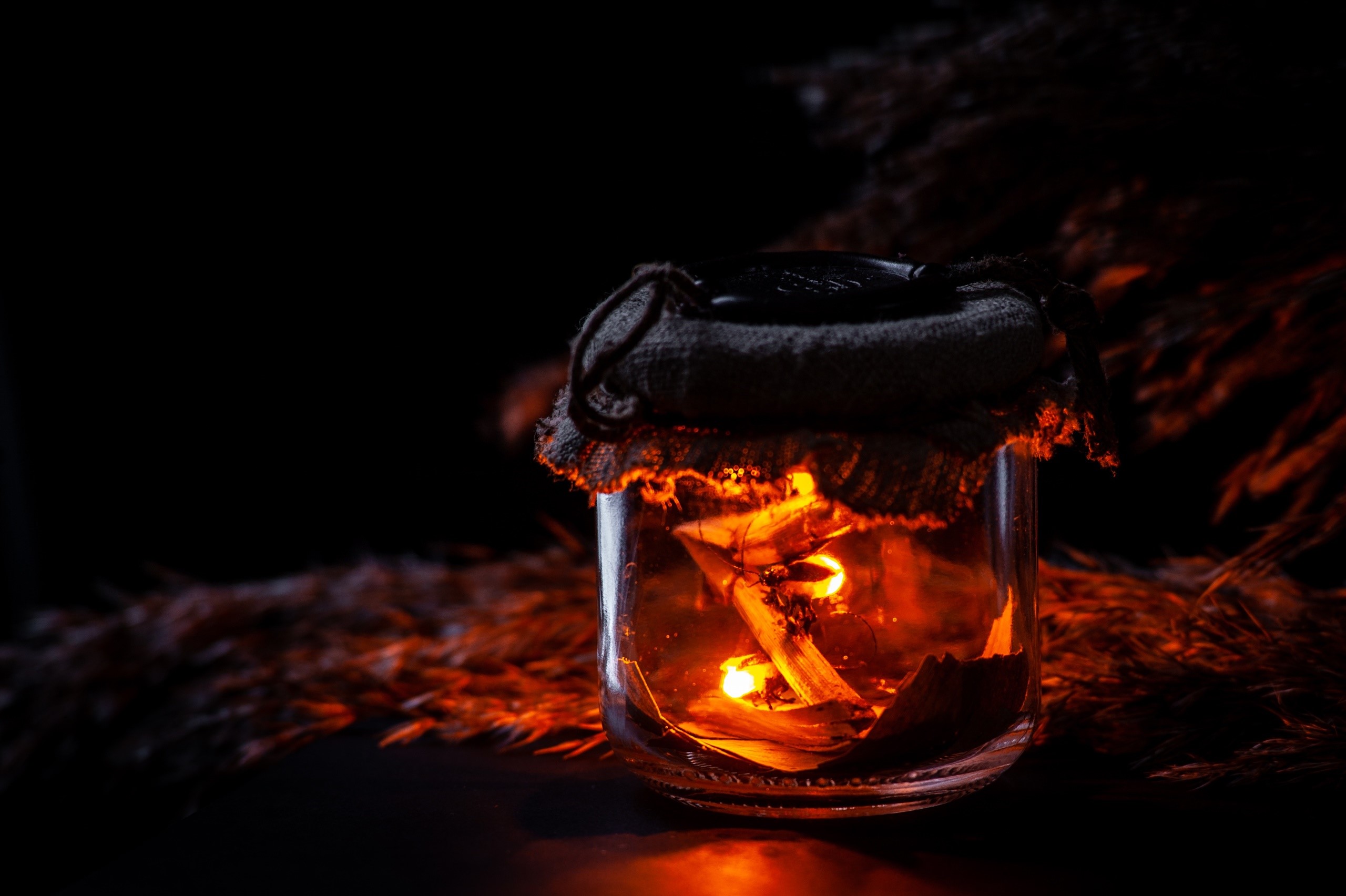 Jar lantern with glowing embers and dried reeds HD Wallpaper