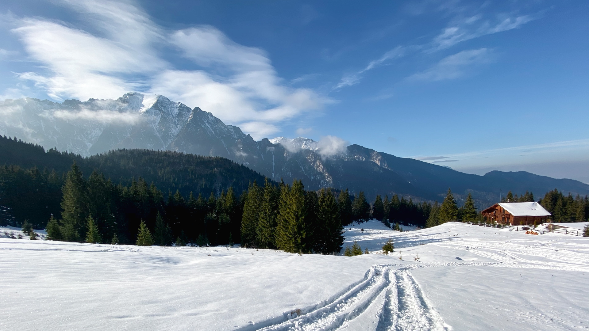 Snowy mountain landscape with a wooden cabin and pine forest HD Wallpaper