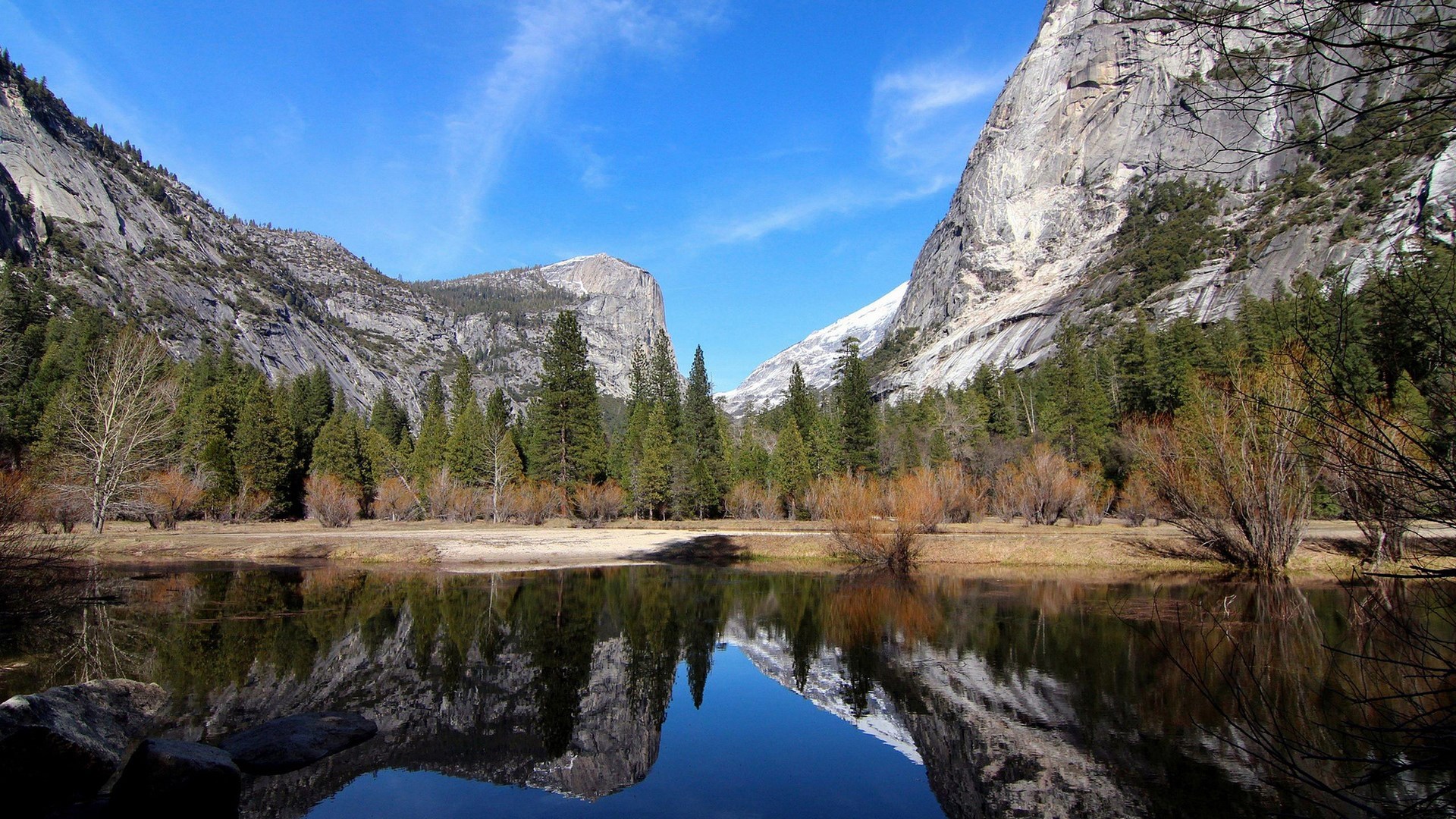 Mountains reflected in a calm lake with pine trees HD Wallpaper