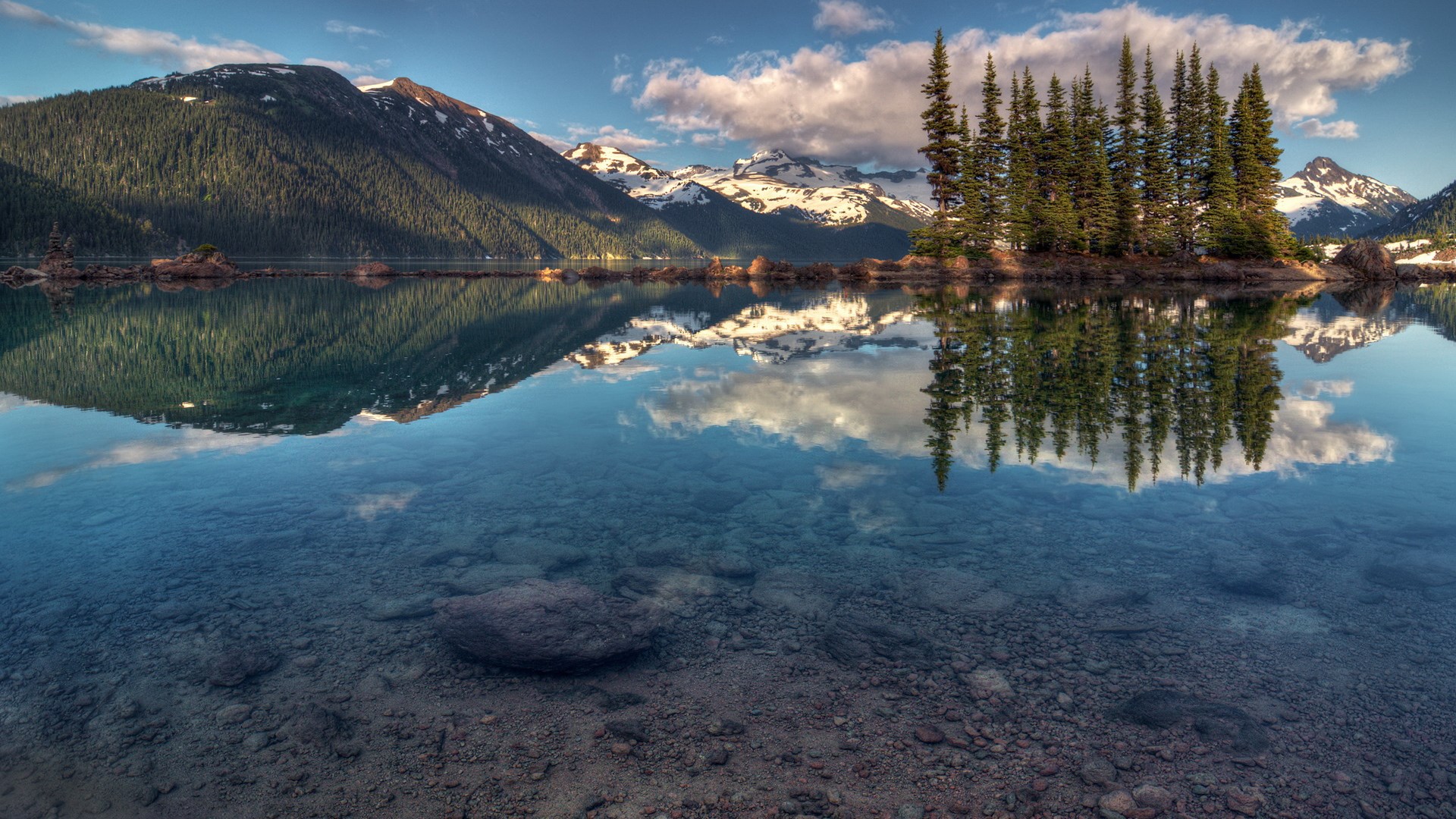 Mountain lake with reflections of trees and snow-capped peaks HD Wallpaper