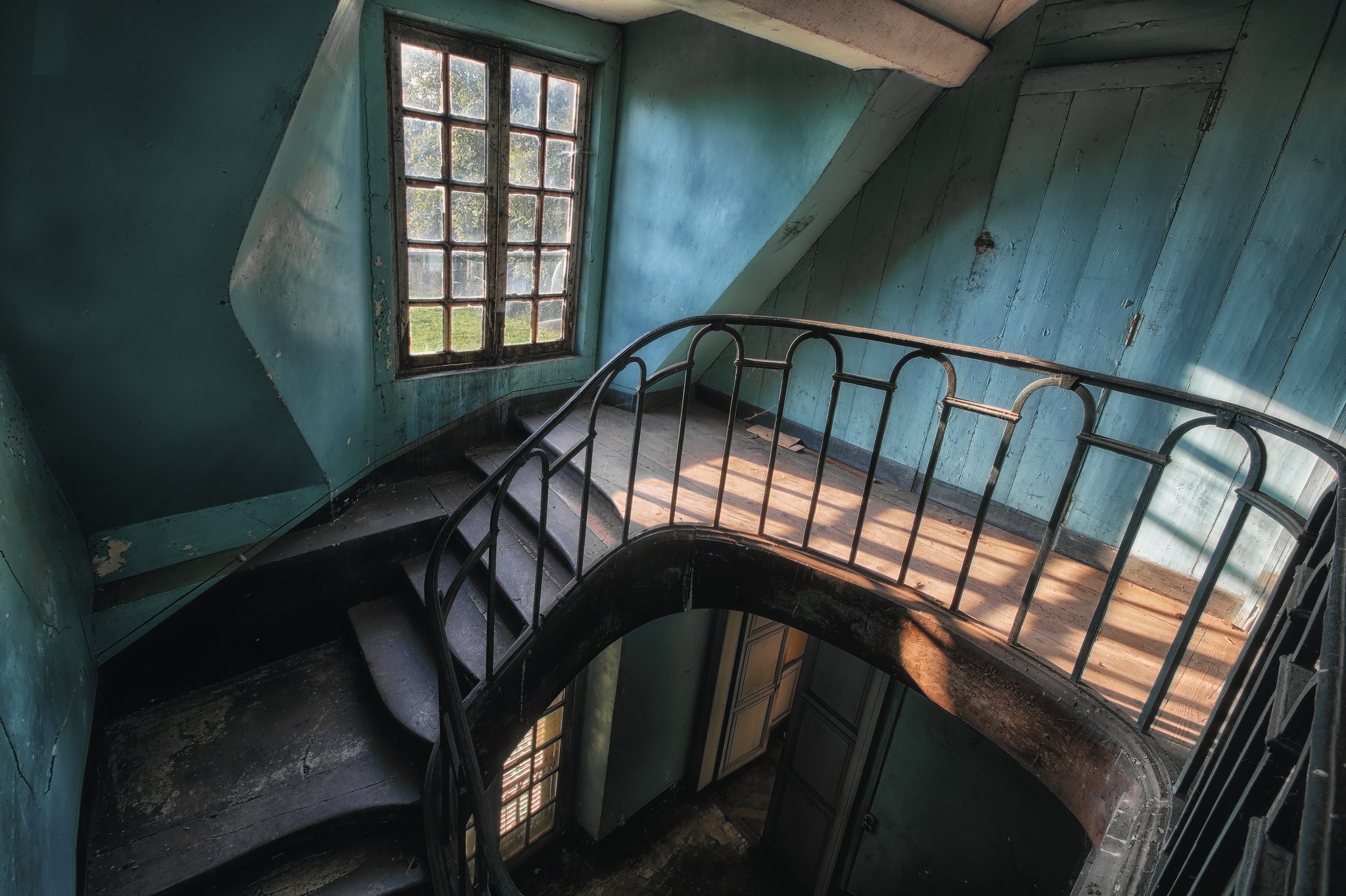 Abandoned house interior with spiral staircase and window HD Wallpaper
