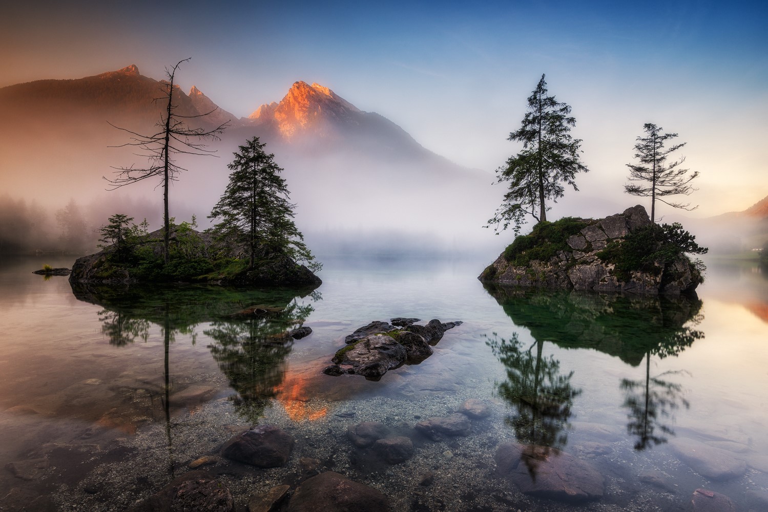 Misty mountain lake with islands and trees at sunrise HD Wallpaper