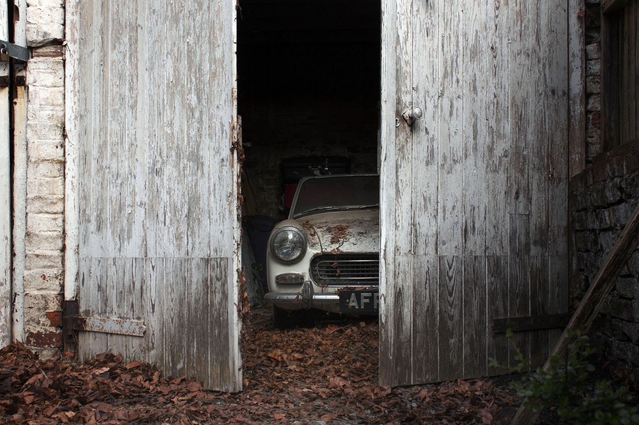 Old car in a dilapidated garage HD Wallpaper