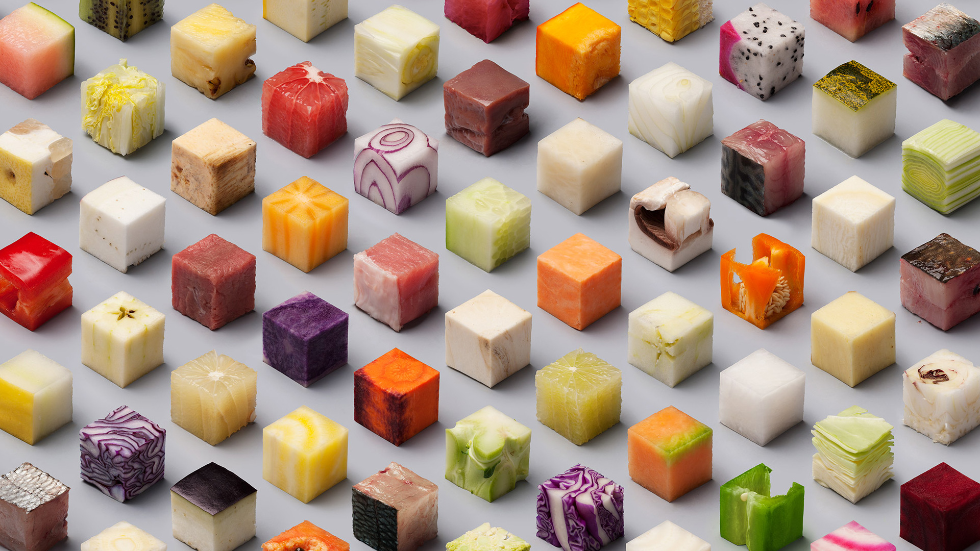 Cubes of cut fruits and vegetables arranged on a gray surface HD Wallpaper