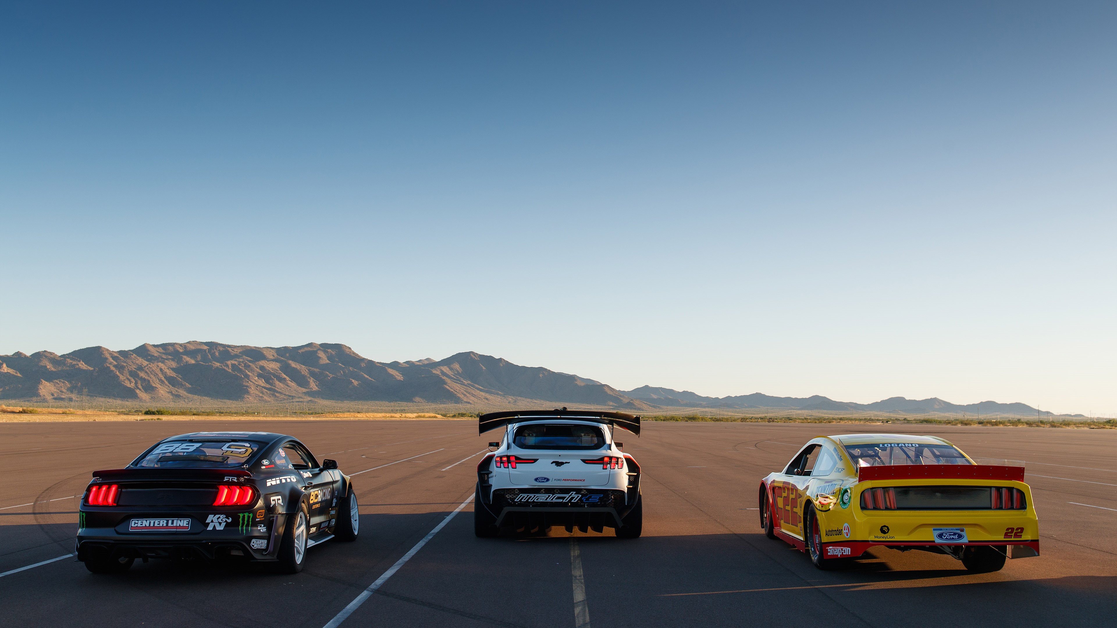 Three Ford Mustangs on a Racetrack HD Wallpaper