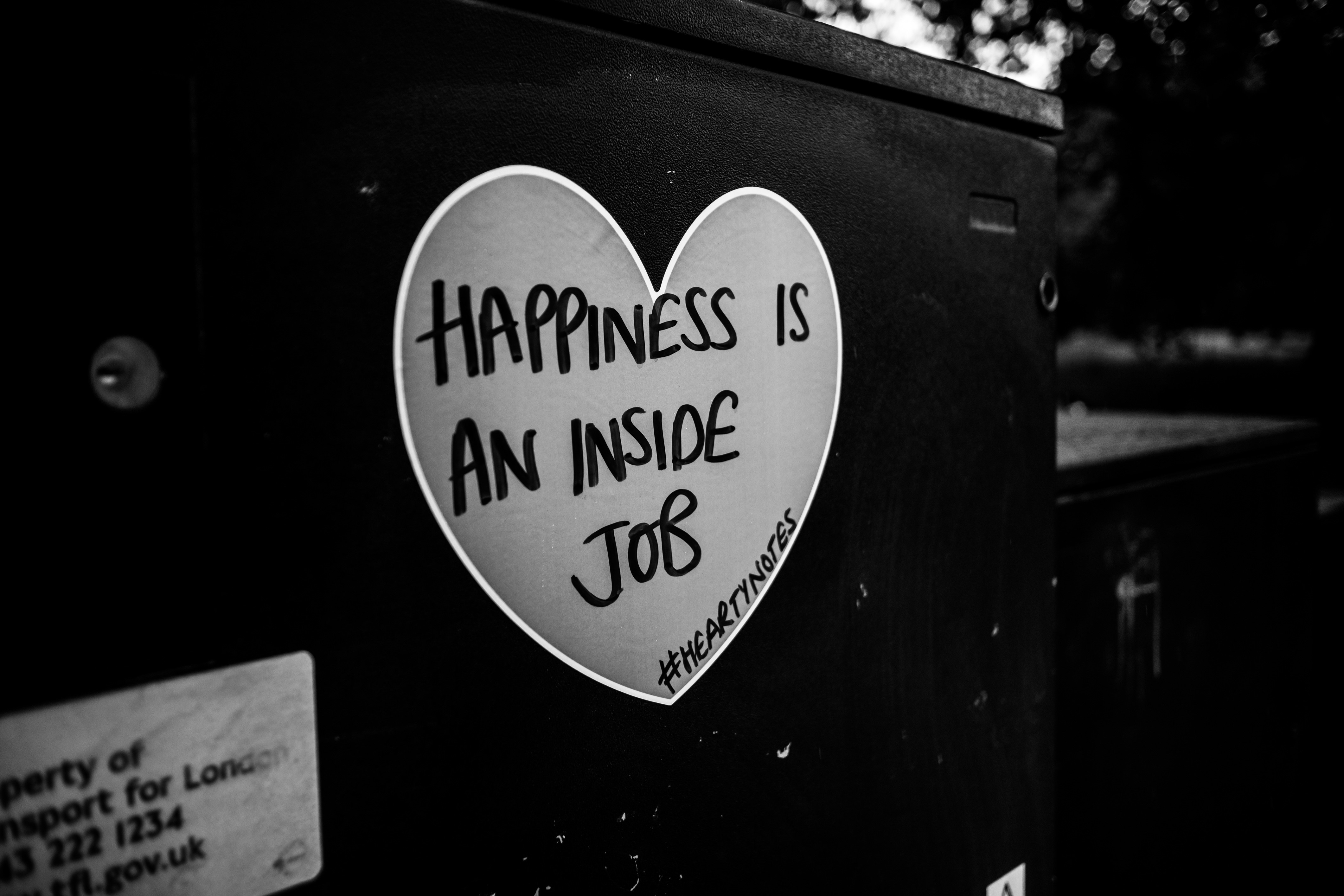 Happiness is an inside job sticker on a dark surface HD Wallpaper