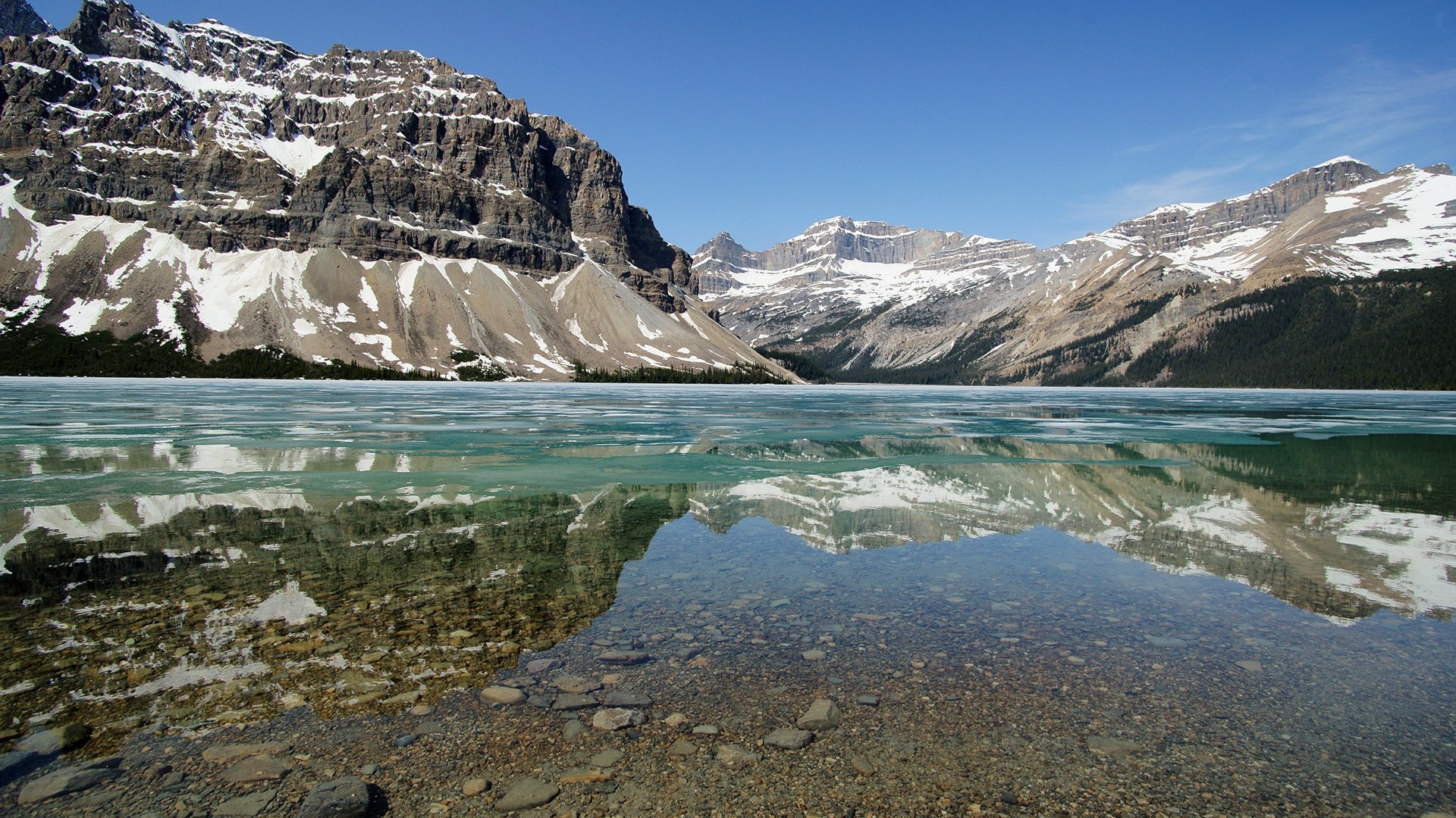 Rocky Mountains reflected in a partially frozen lake HD Wallpaper