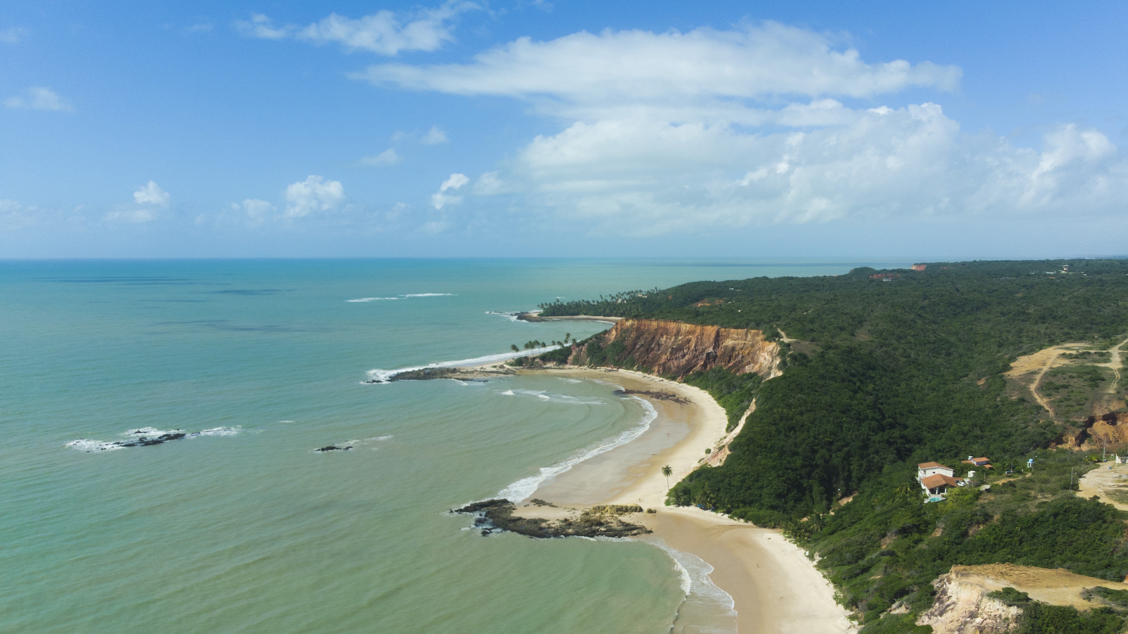 Aerial view of a tropical coastline with cliffs and ocean HD Wallpaper