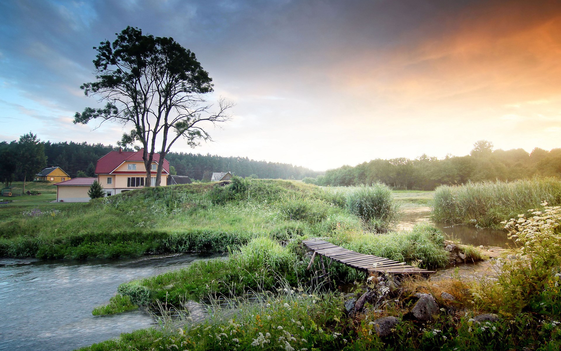 Rural landscape with a house, river, and bridge at sunset HD Wallpaper