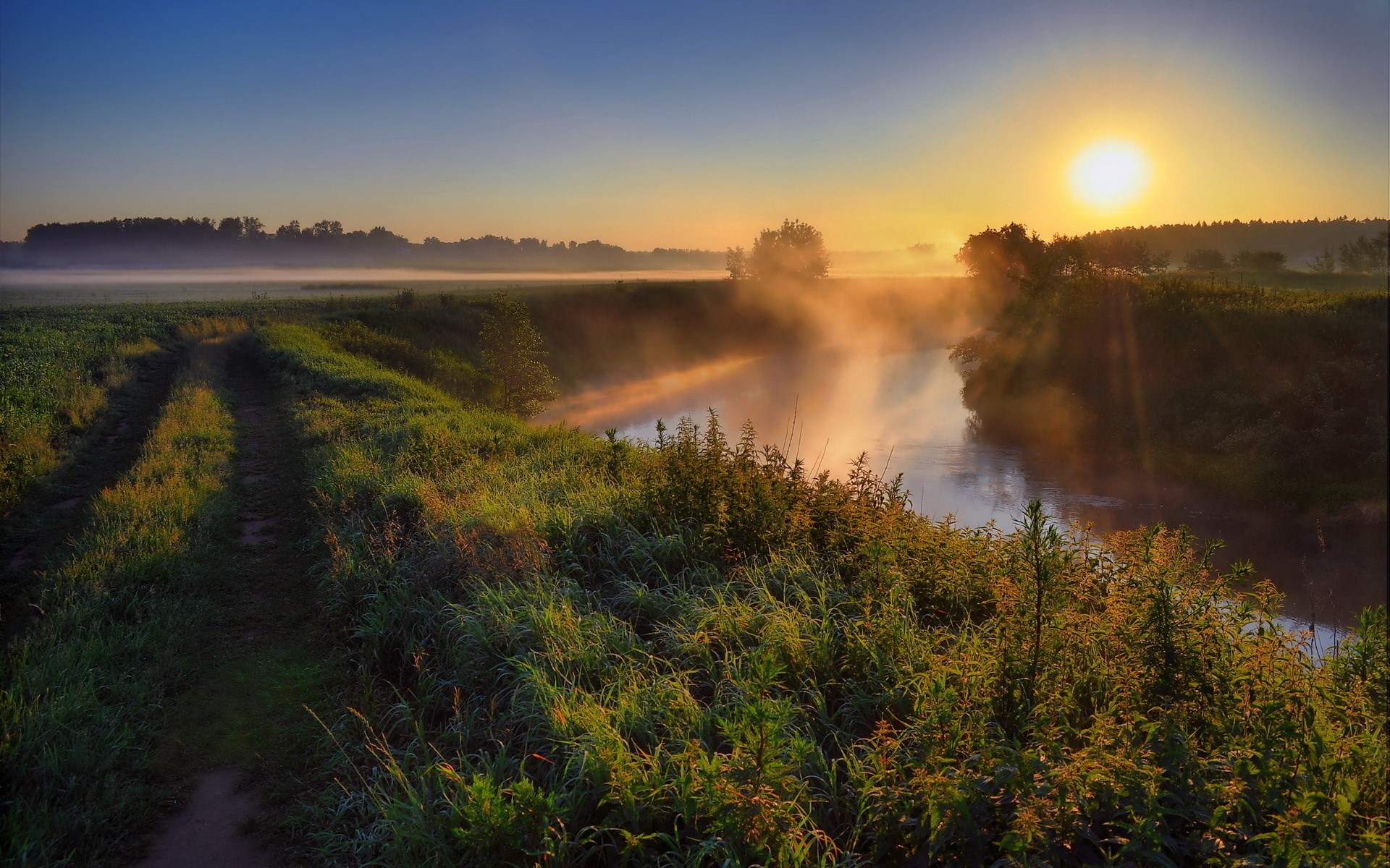Misty river at sunrise with a dirt path HD Wallpaper