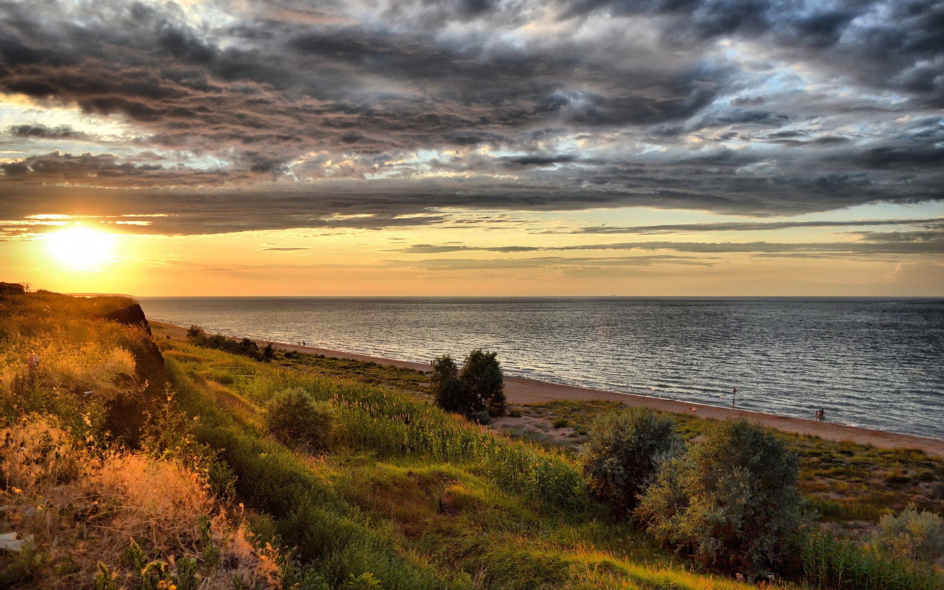 Sunset over the sea with dramatic clouds and grassy cliff HD Wallpaper